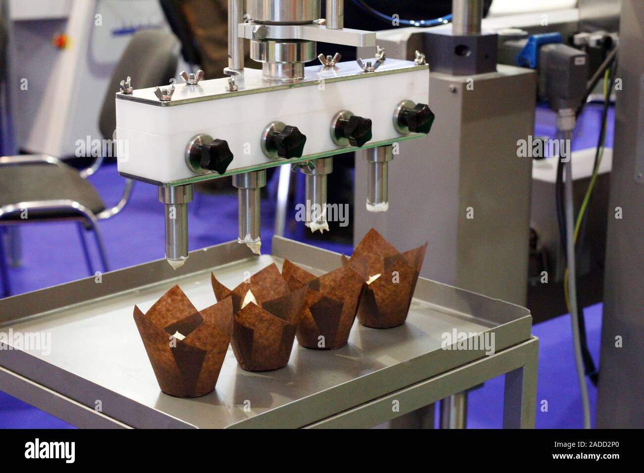 Hacer pasteles en una línea de producción. Una máquina para hornear con una  cinta en la que se encuentra la confitería. El funcionamiento de la máquina.  Mo Fotografía de stock - Alamy