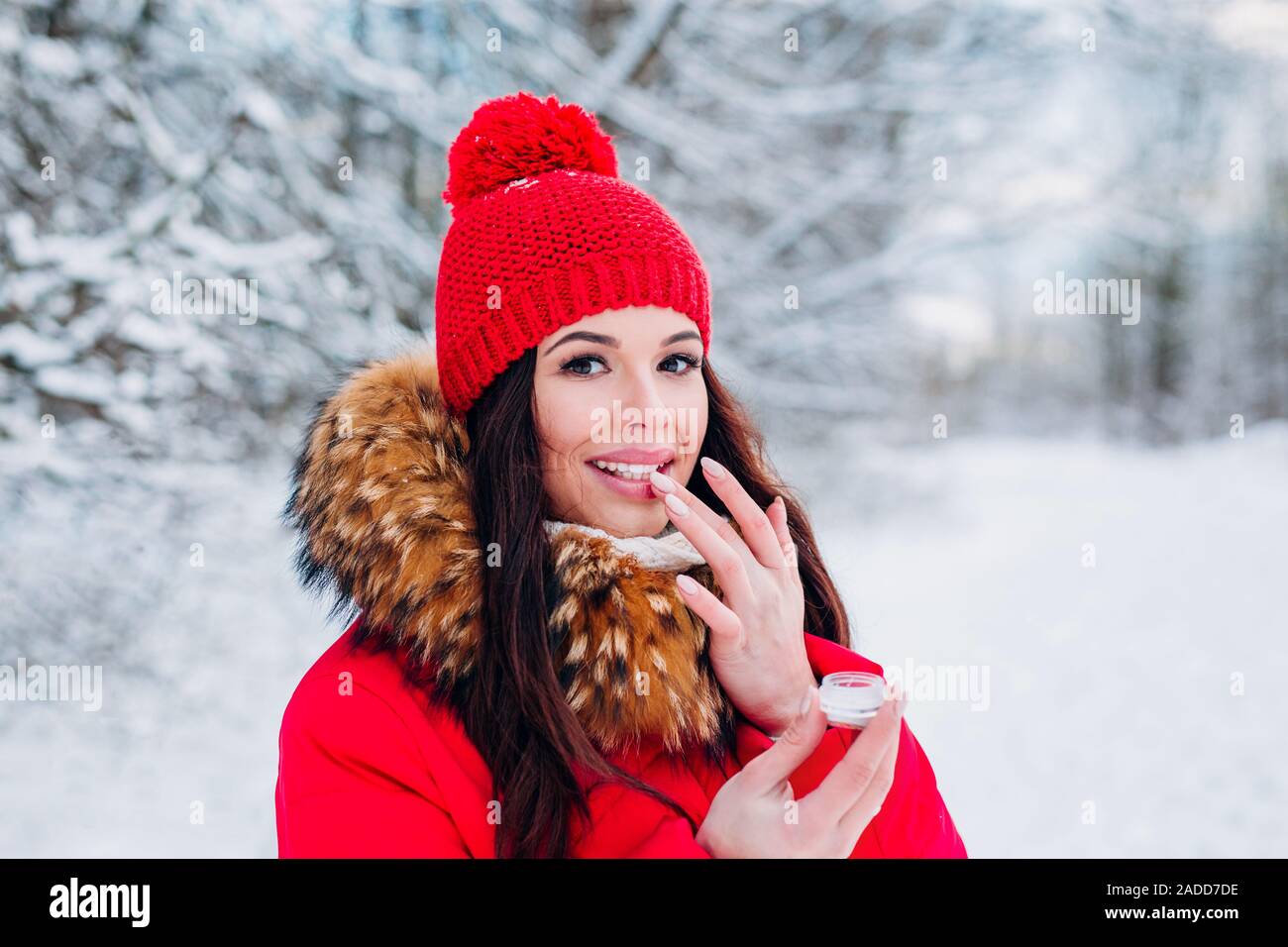 Chica proteger los labios con protector labial en invierno Foto de stock