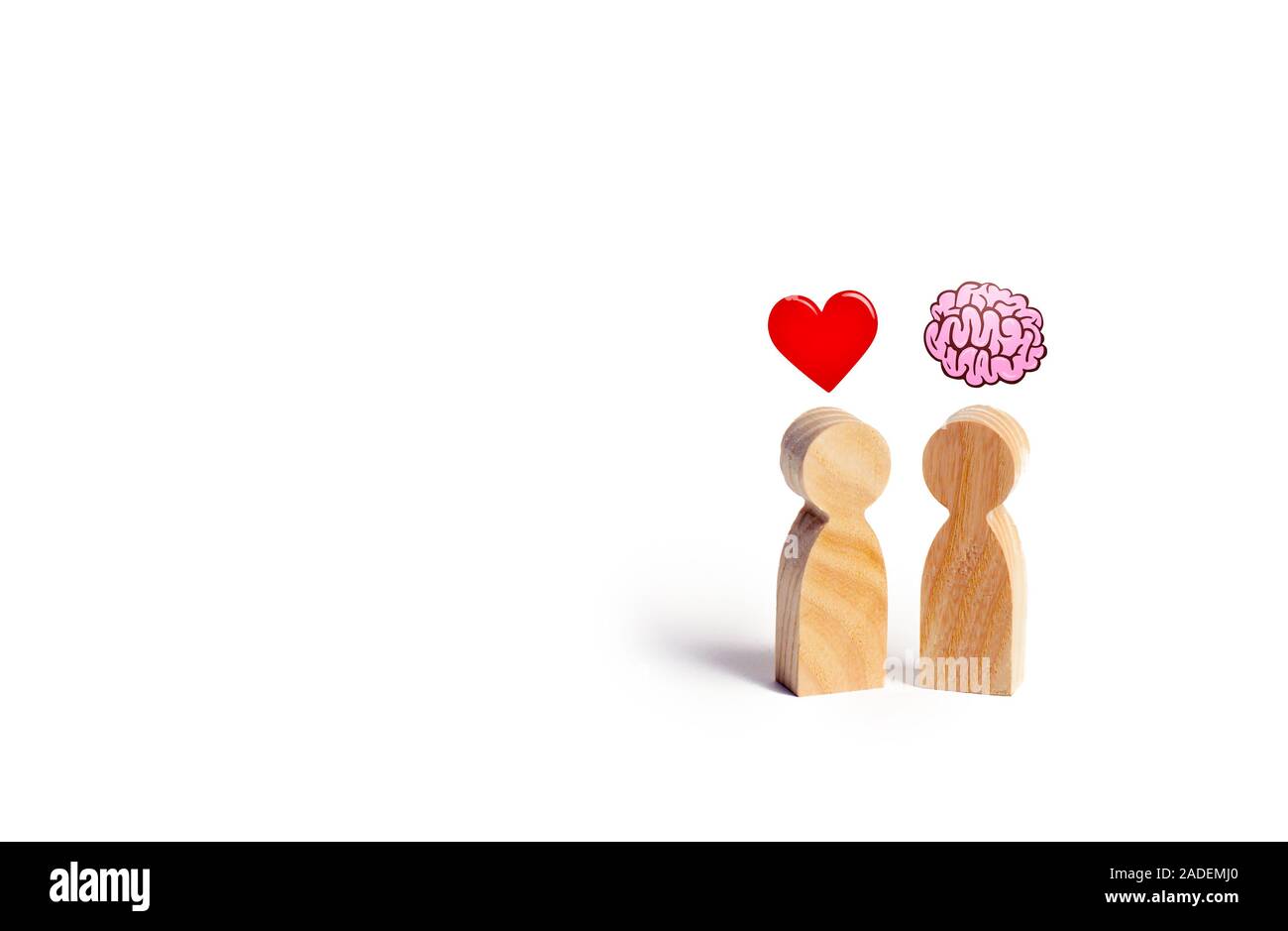 Dos figuras de madera con la imagen del cerebro y el corazón. El equilibrio  entre el amor y la mente. La familia frente al trabajo o carrera. Psicología  de la familia. Problema