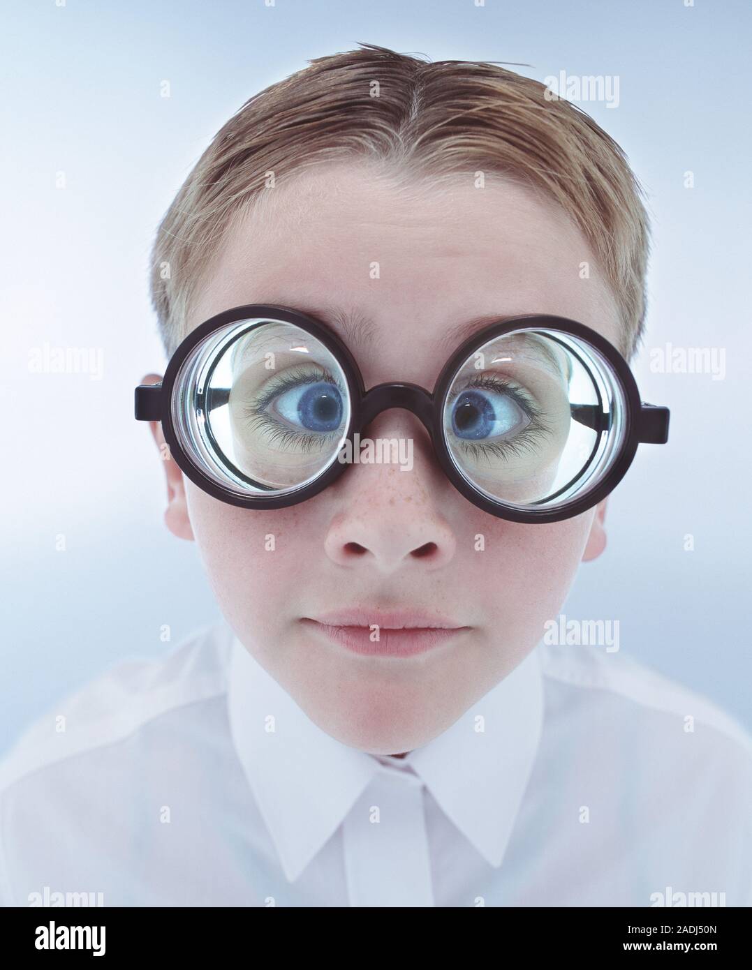 Espectáculos. Niño usando gafas o gafas de óptica con lentes muy fuerte.  Los gruesos lentes de lupa son los ojos del muchacho Fotografía de stock -  Alamy