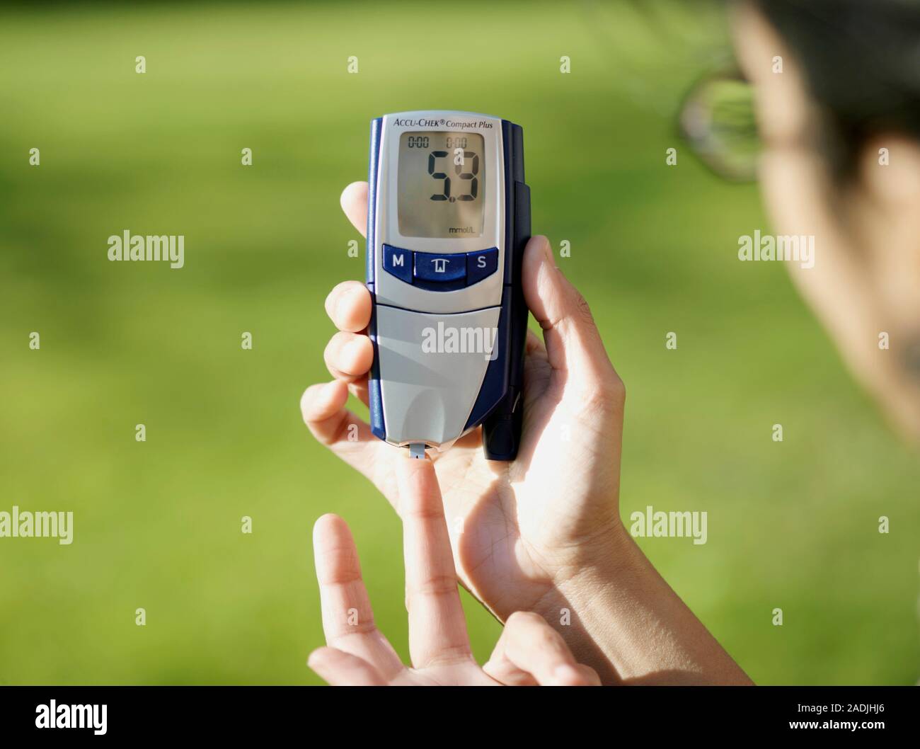 Se realiza la medición de azúcar en la sangre por diabetes. La máquina (un  glucómetro) analiza el nivel de azúcar en la sangre (glucosa), nivel de una  gota de sangre. En th