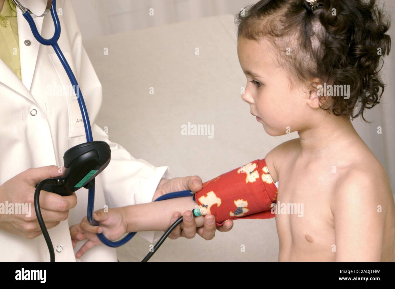 Examen pediátrico. Imagen 12 de 14. Doctor teniendo una chica la presión  arterial con un esfigmomanómetro. El manguito se coloca alrededor del brazo  del niño Fotografía de stock - Alamy