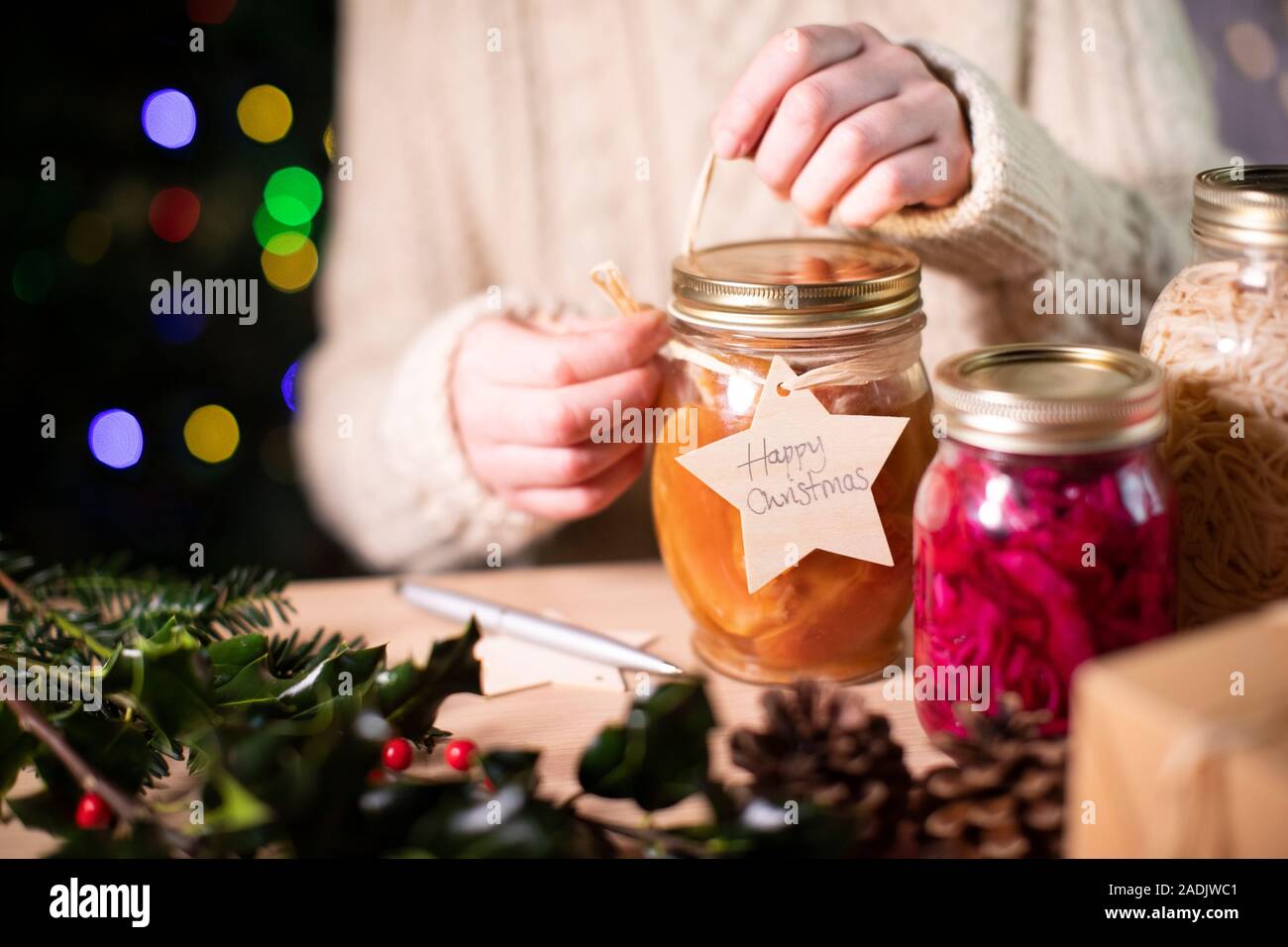 Poner etiqueta del regalo de madera reutilizables en tarros casera de conservas de fruta para regalo de Navidad ecológica Foto de stock
