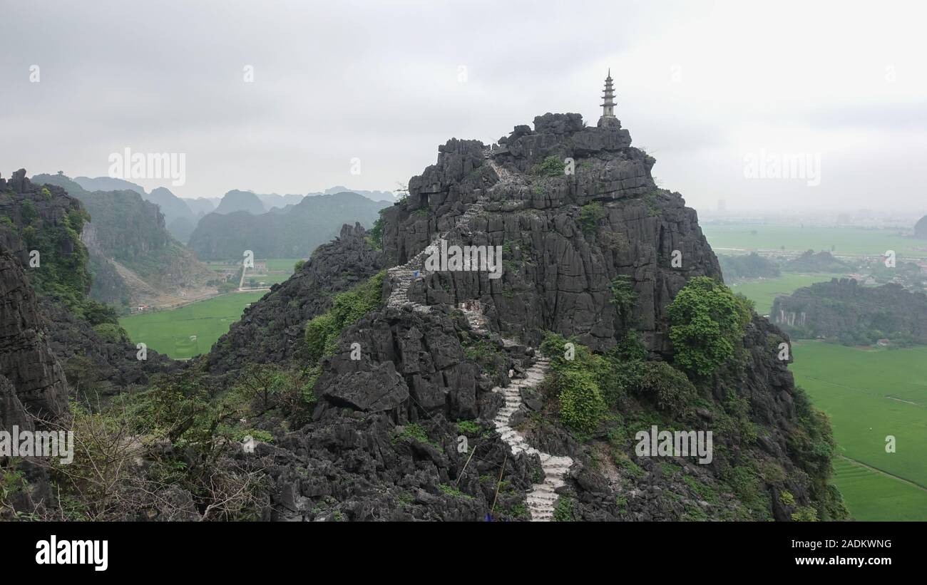 Una vista del pico de una montaña y un camino a la cumbre en el bello paisaje de Tam Coc, Ninh Binh, Vietnam Foto de stock