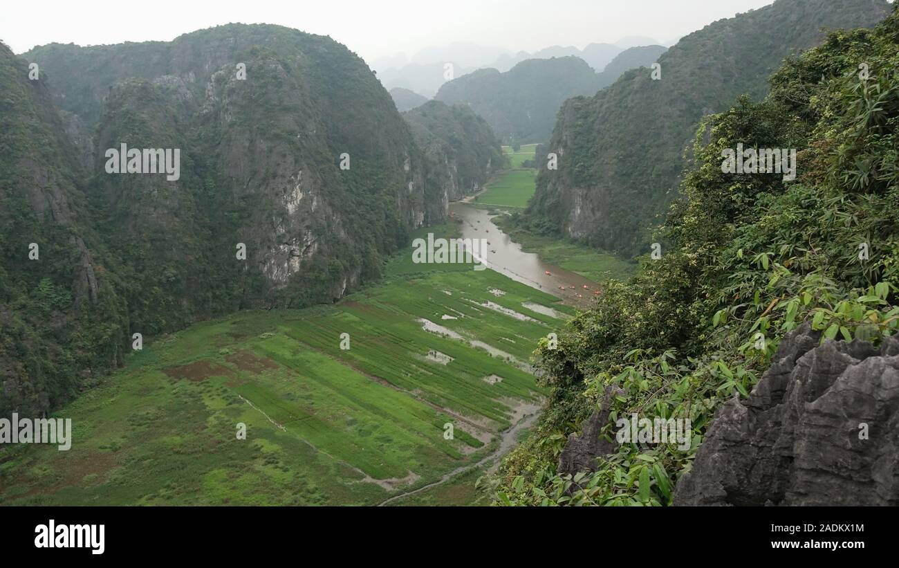 Vista de un río en un valle entre montañas gigantes en Tam Coc, Ninh Binh, Vietnam Foto de stock