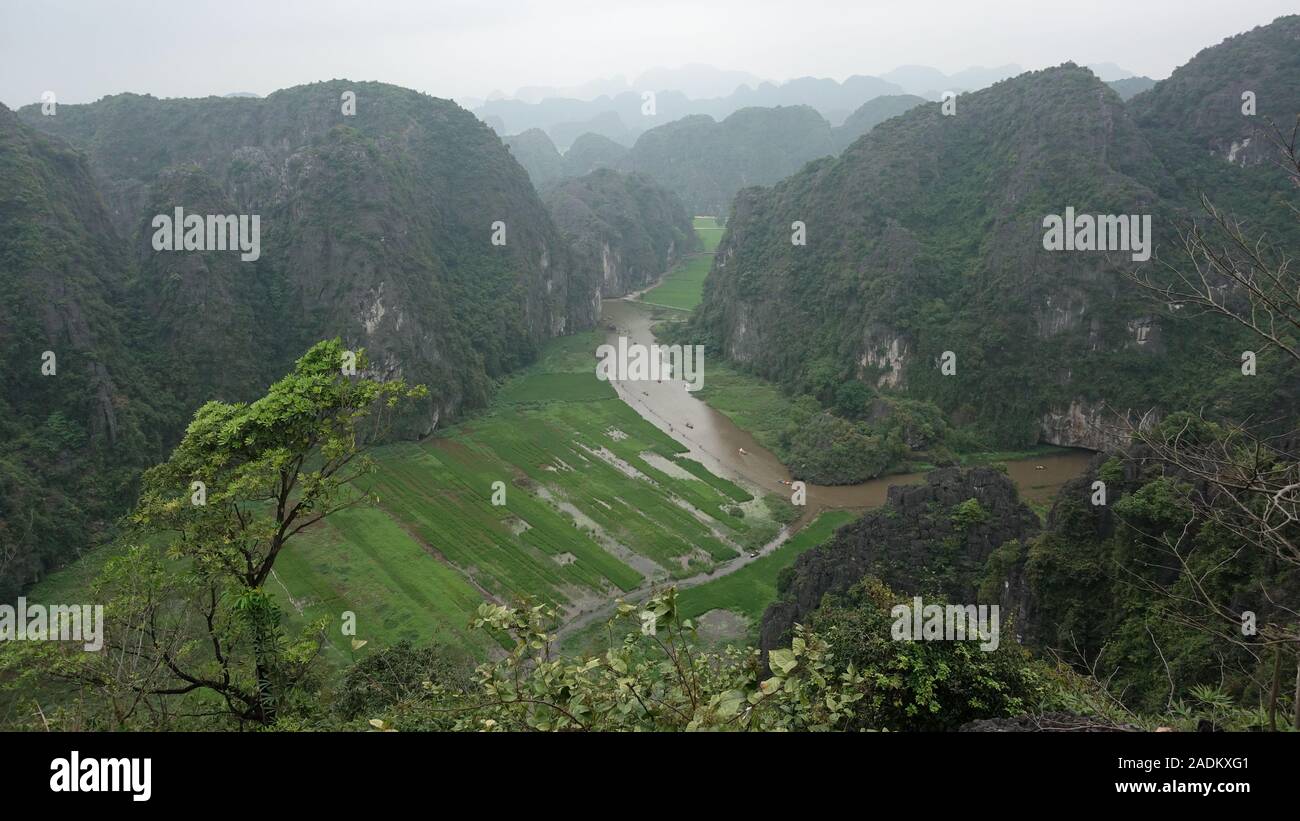 Vista de un río en un valle entre montañas gigantes en Tam Coc, Ninh Binh, Vietnam Foto de stock