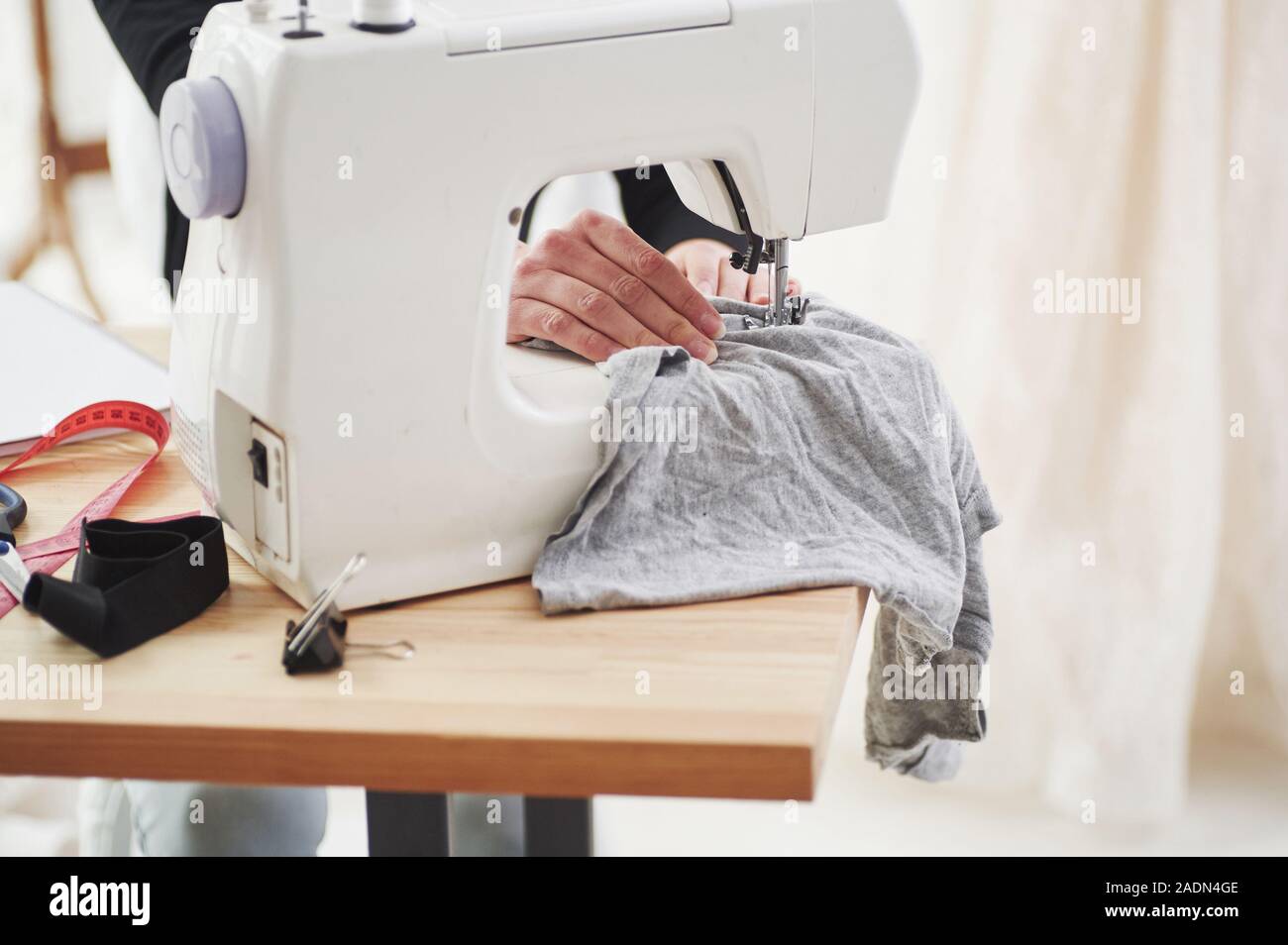 Las manos de la mujer en el trabajo. Diseñador de moda femenina trabaja en la ropa nueva en el taller Foto de stock