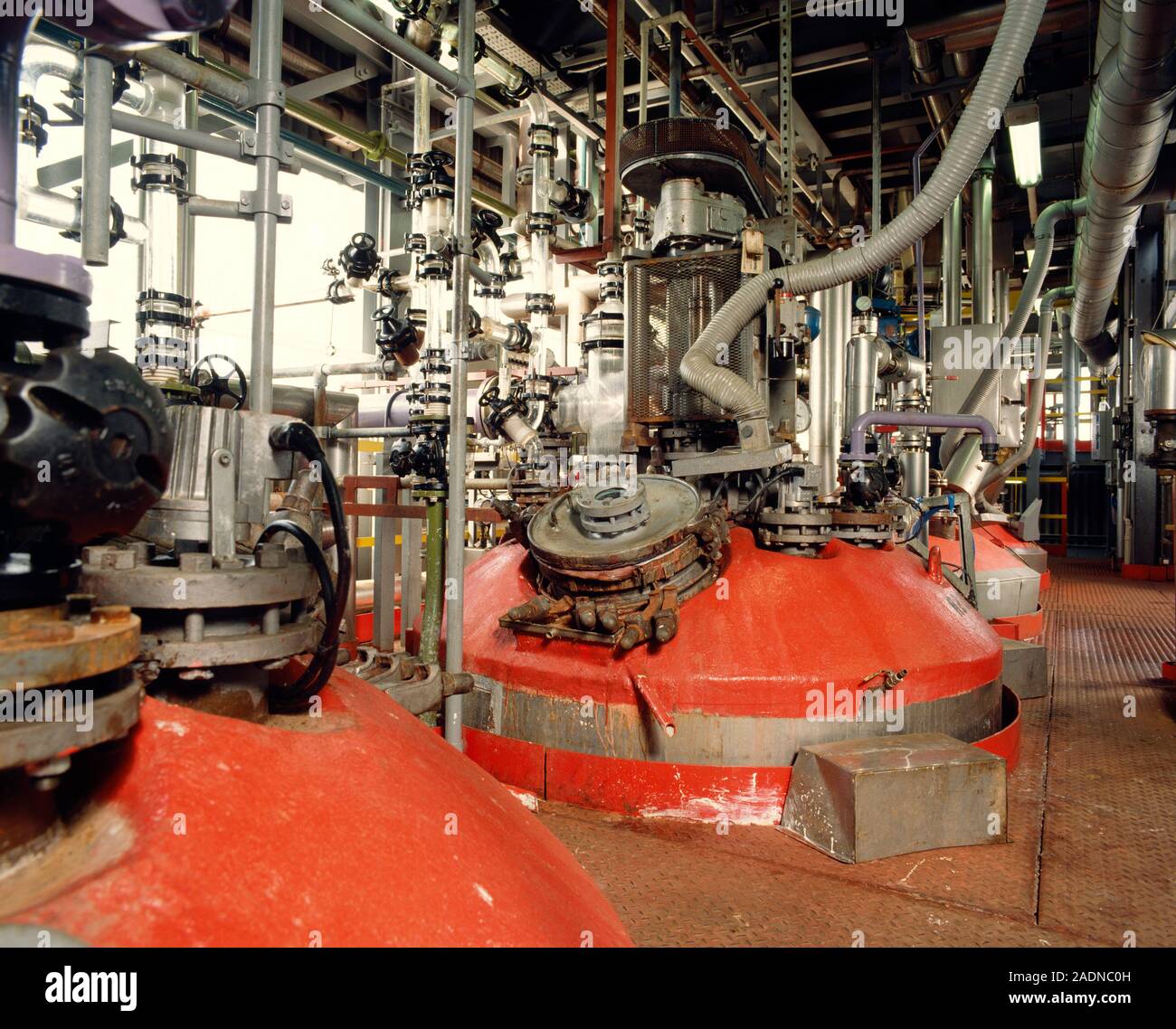 Recipientes de reacción química. Fila de recipientes de reacción de color  rojo en una fábrica de productos químicos Fotografía de stock - Alamy