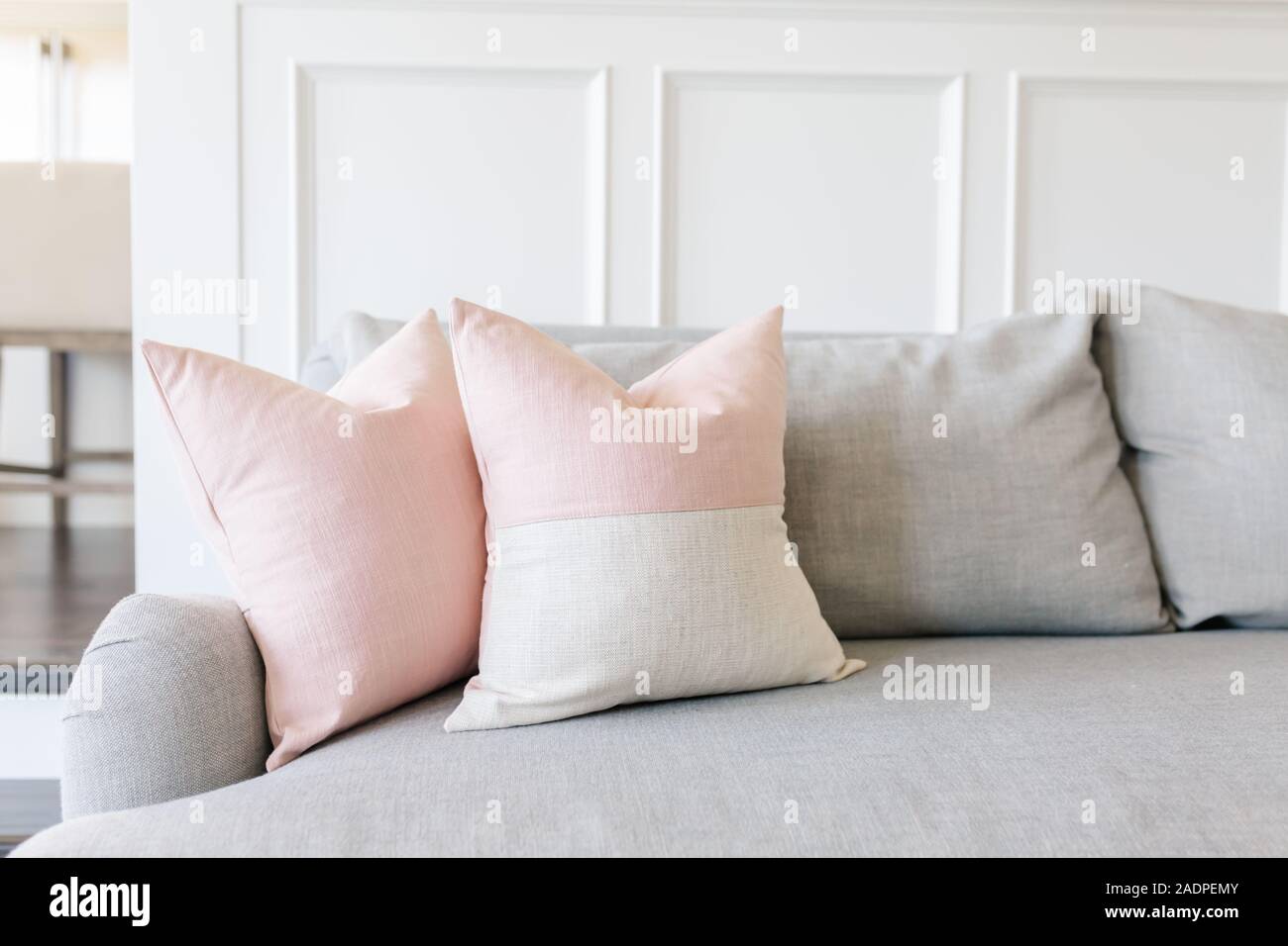 Rosa almohadas en un sofá gris Fotografía de stock - Alamy