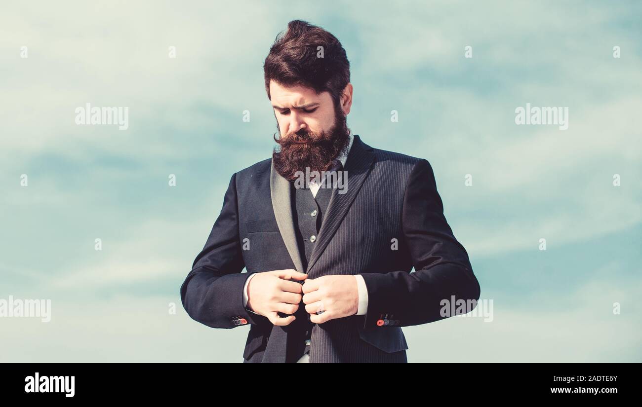 Moda masculina ropa formal. Tendencia de moda. Guy barba y bigote vestir ropa  formal. Justo a la derecha. El empresario con el rostro barbado de fondo  del cielo. Traje impecable. Traje formal