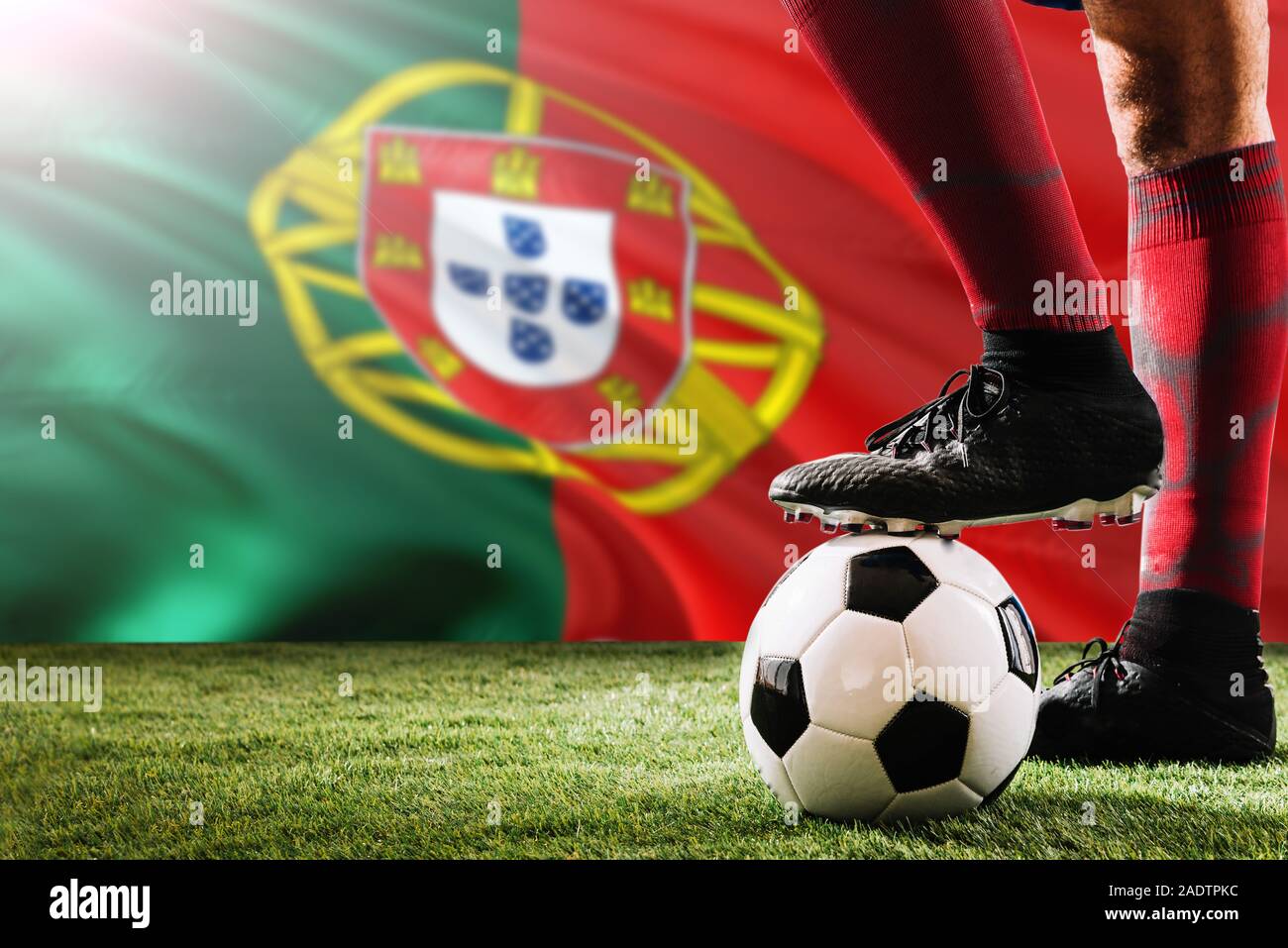 Cerrar las piernas de la selección portuguesa de fútbol jugador en calcetines, zapatos rojos sobre la pelota en el punto penal o free kick jugando sobre la hierba. Foto de stock