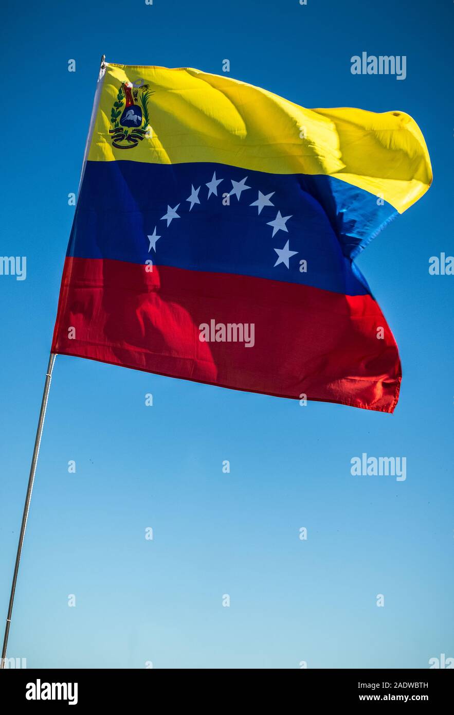 Bandera de Venezuela aleteo con un fondo de cielo azul. Foto de stock