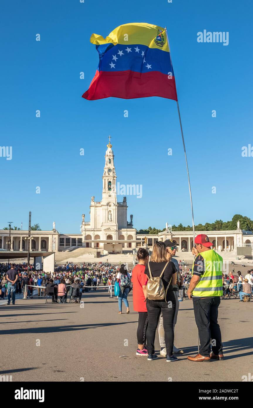 Fátima, Portugal - 12 de mayo de 2019: el grupo de peregrinos con bandera de Venezuela ondeando en el Santuario de Fátima, Portugal. Foto de stock