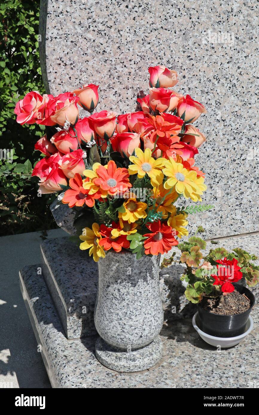 Flores en un jarrón sobre la lápida Fotografía de stock - Alamy