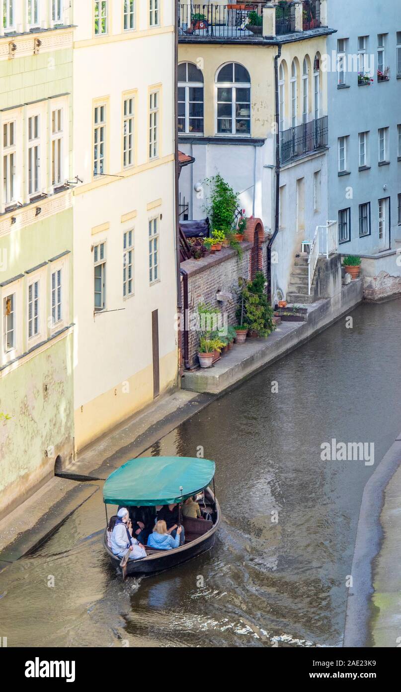 La pequeña embarcación con turistas en el canal Čertovka en Lesser Town, Praga, República Checa. Foto de stock