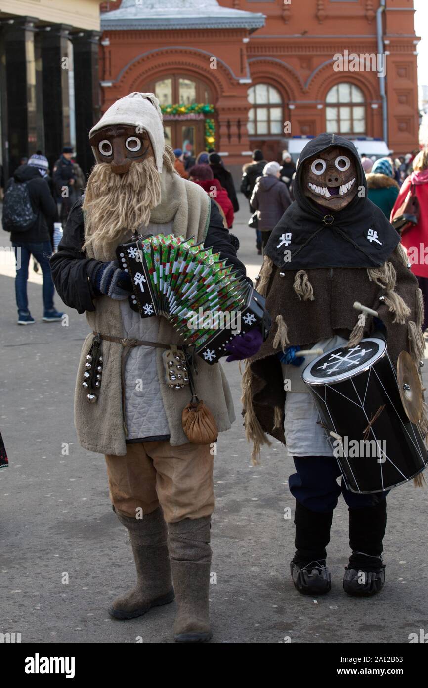 Héroes paganos, en máscaras, como ratones, de pie en la calle en la primavera, con instrumentos musicales y cantando canciones. Rusia 2018 Foto de stock