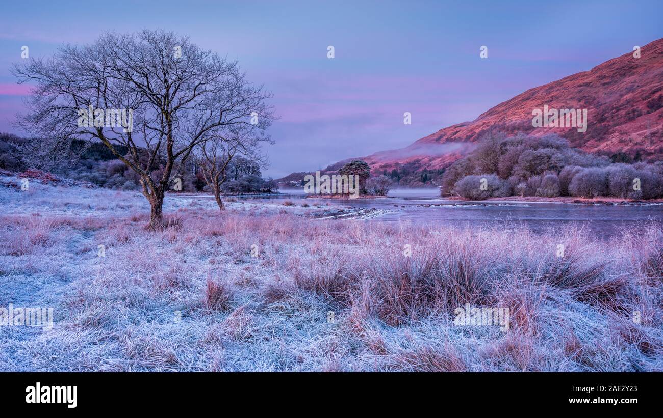 El frío y la helada mañana de invierno con niebla deriva en Loch Awe en Highlands Escocesas esperando el sol Foto de stock