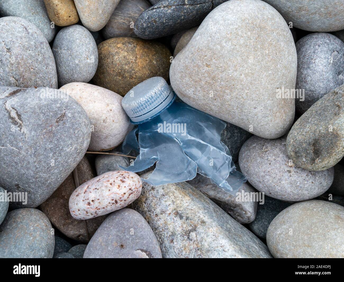Restos de botella de plástico rotos entre los guijarros en la playa, Uragaig escocés, Isla de Colonsay, Scotland, Reino Unido Foto de stock