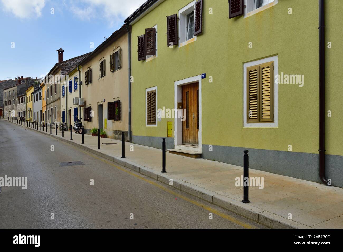Vista de la calle por la carretera principal a través de la pintoresca pequeña ciudad de Vrsar, al norte de Croacia, con modernas viviendas tradicionales Foto de stock