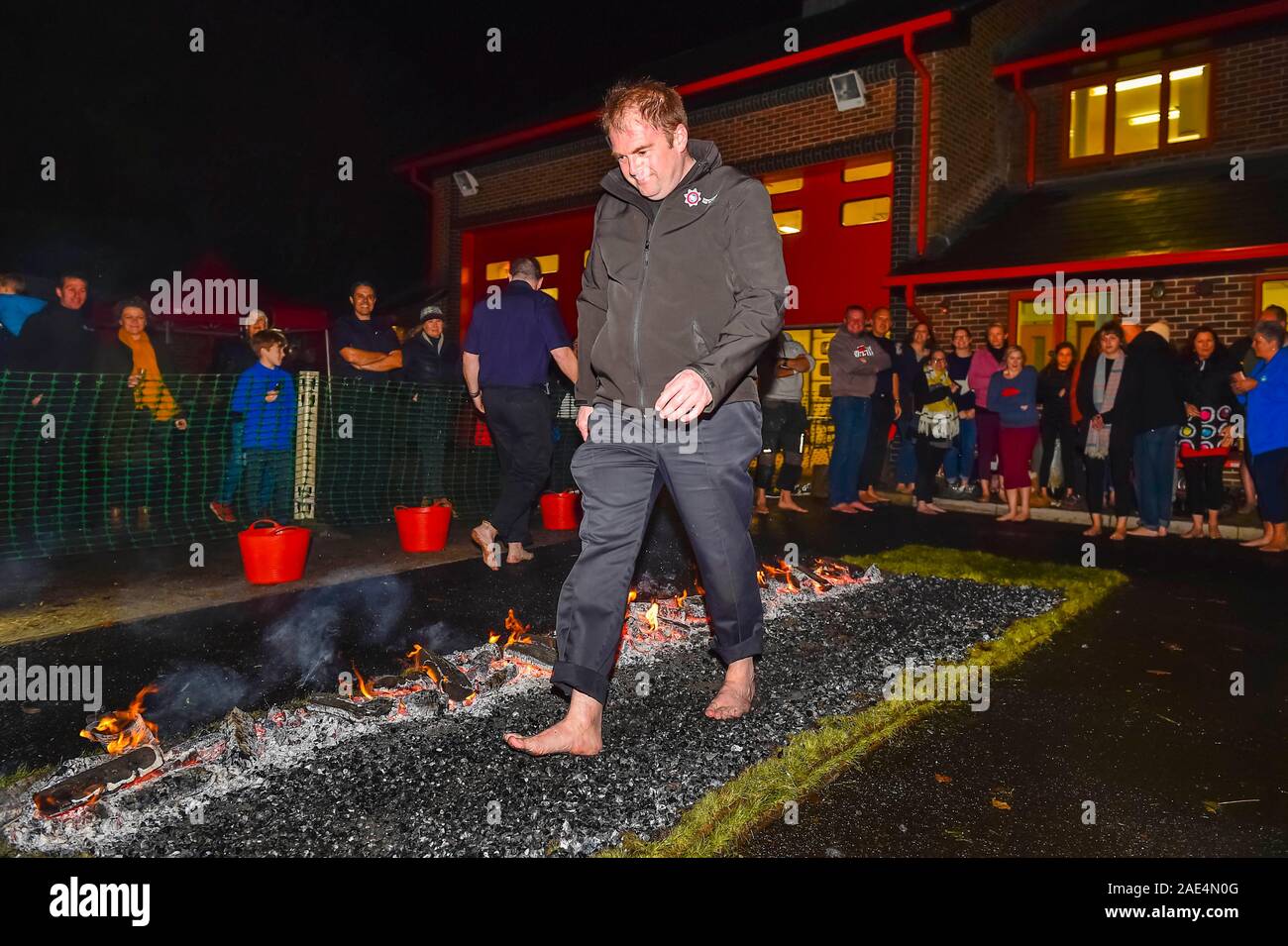 Bridport, Dorset, Reino Unido. El 6 de diciembre de 2019. Los miembros del público caminando sobre brasas de que tomen parte en una organización de caridad en la Comunidad Bridport firewalk Estación de Bomberos en Dorset en la ayuda de los Bomberos de la caridad. Crédito de la imagen: Graham Hunt/Alamy Live News. Foto de stock
