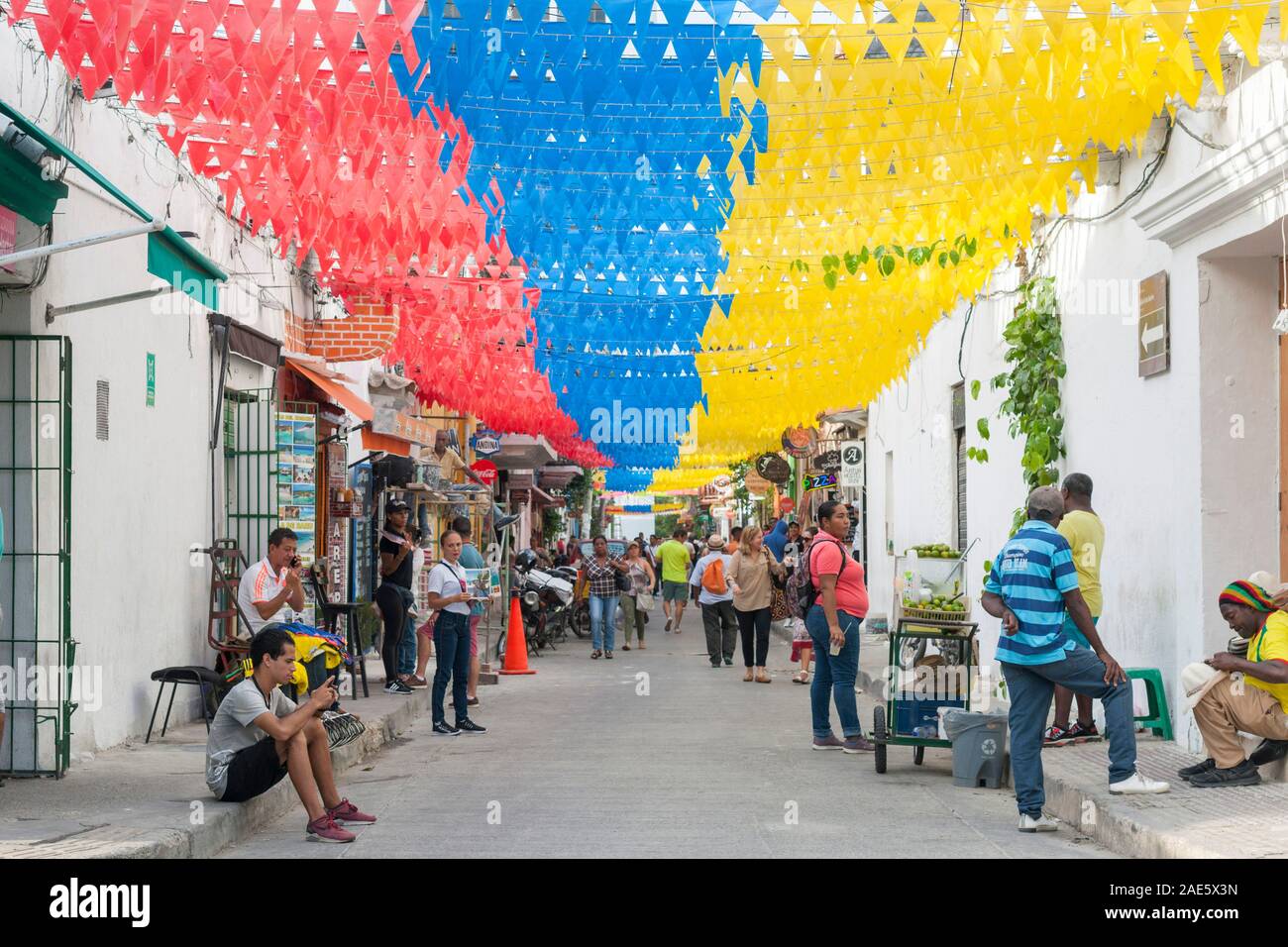 Banners en los colores nacionales de Colombia adornando 10th street (Carrera 10) en el barrio Getsemani de Cartagena, Colombia. Foto de stock