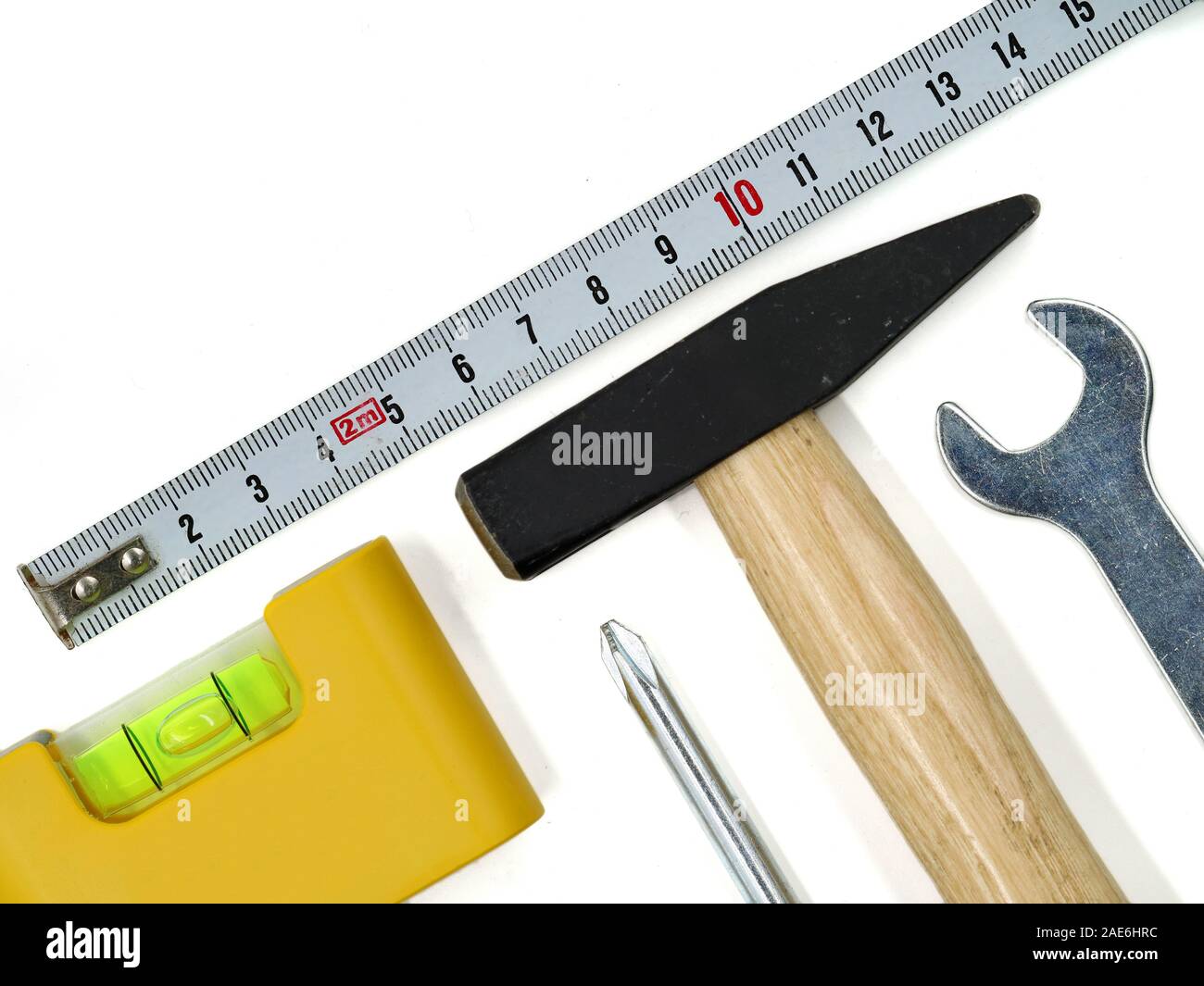 Vista superior de herramientas de trabajo aislado sobre fondo blanco. Conjunto de herramientas con un martillo, nivel, destornillador, llave y cinta métrica, espacio de copia Foto de stock