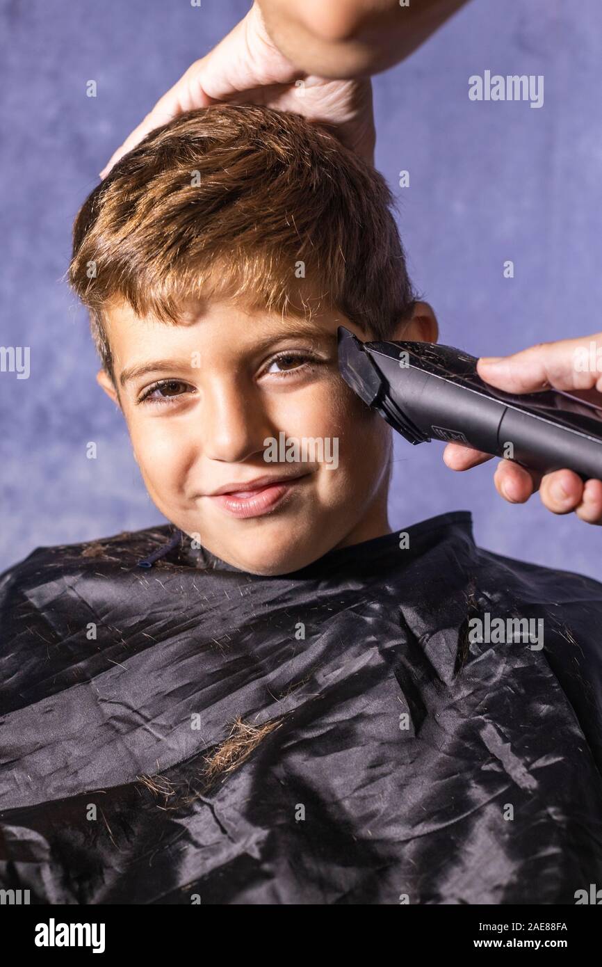 Niñito cortarse el pelo con una máquina de cortar Fotografía de stock -  Alamy