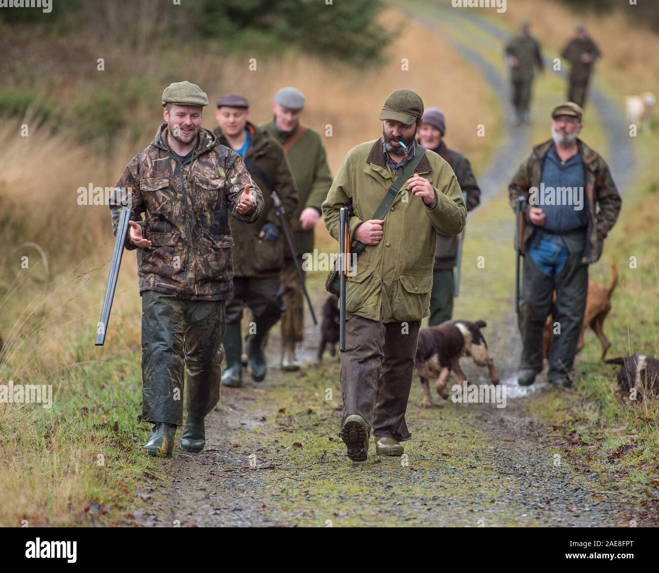 Grupo de cazadores con armas de fuego y perros Foto de stock