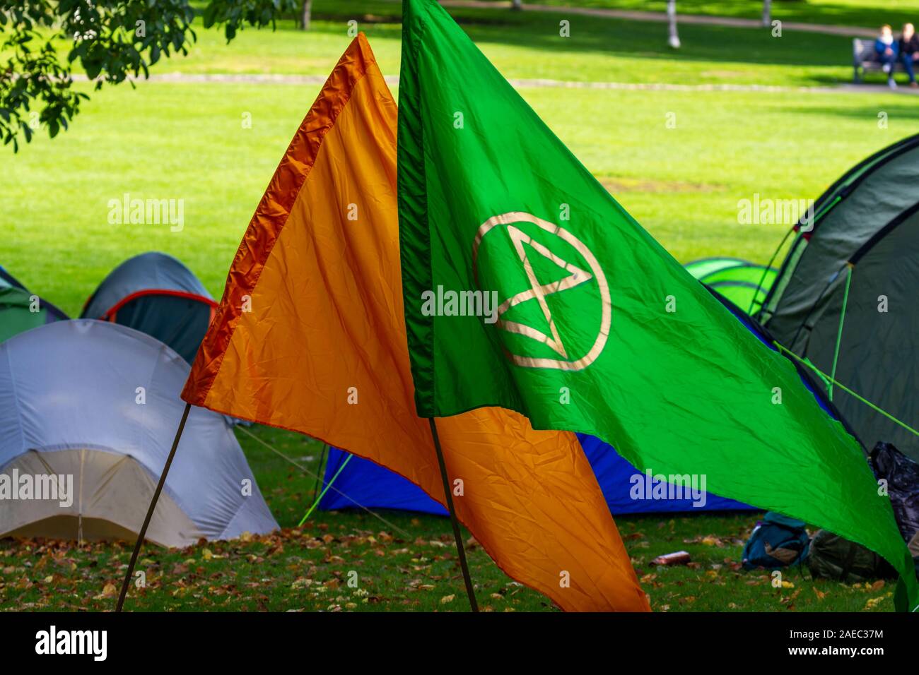 Extinción Rebelión de banderas verdes y naranjas con símbolo. Grupo de activismo para combatir el cambio climático y proteger el medio ambiente. Nadie. Dublín, Irlanda Foto de stock