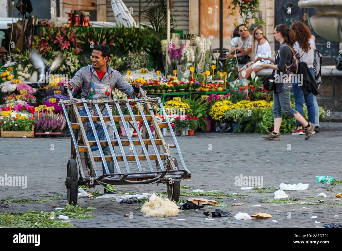 Plaza del mercado sonriente vendedor empujando un barrow en Campo de' Fiori, en Roma, Italia Foto de stock