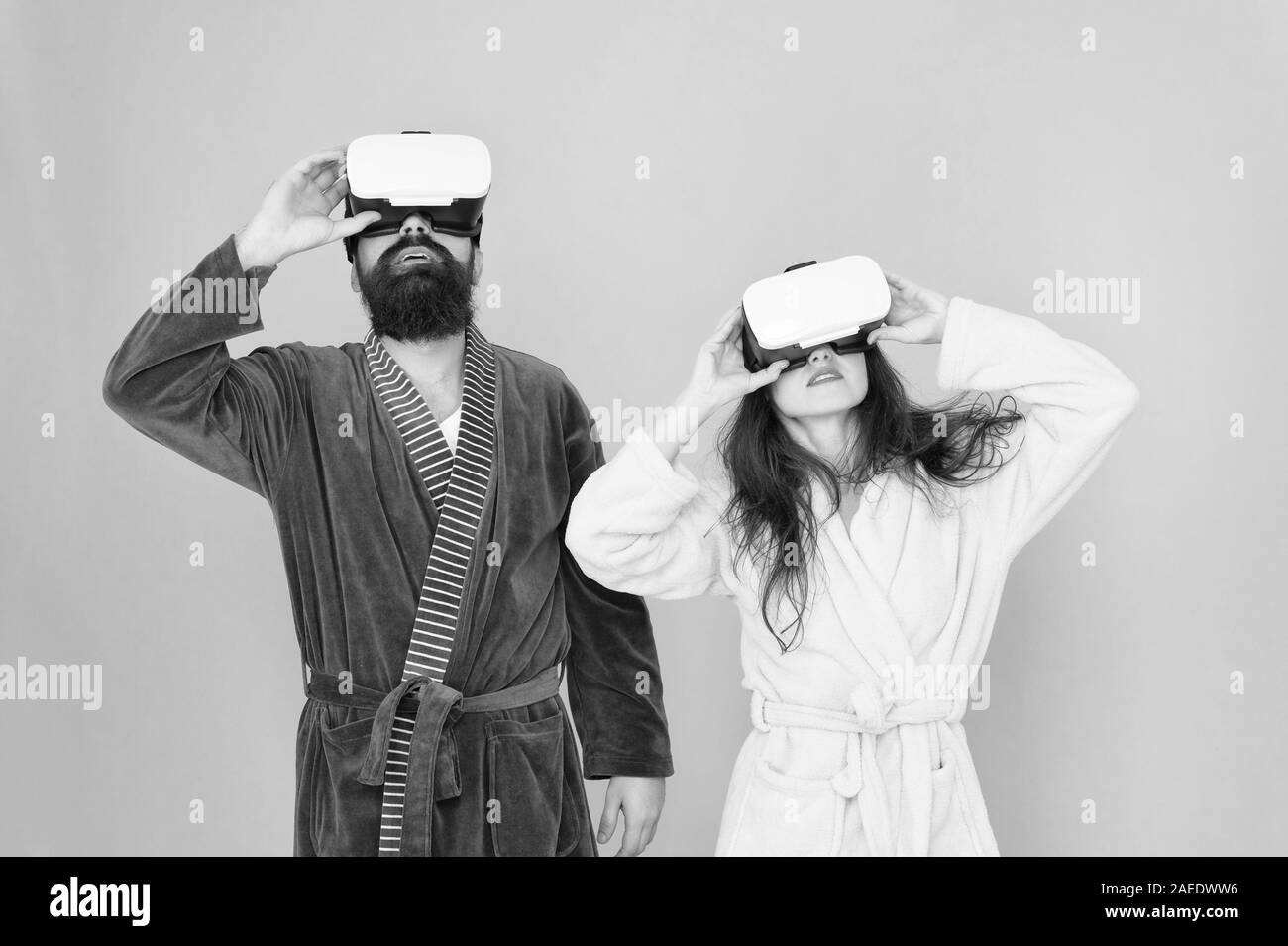 Mañana comienzo con la tecnología del futuro. digital pareja. La innovación en las relaciones familiares. Crea tu realidad. Nuevo mundo de la realidad virtual. Familia par llevar auriculares vr. chica y hombre relajarse en albornoz. Foto de stock