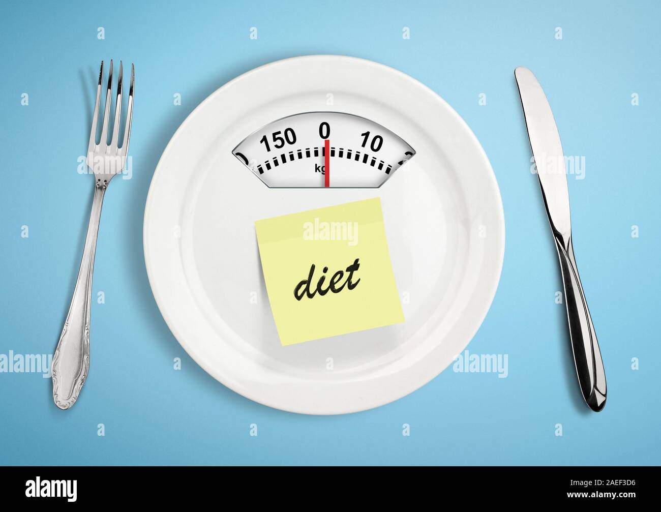 Concepto de dieta y pérdida de peso. Placa con escala máquina de pesaje sobre azul Foto de stock
