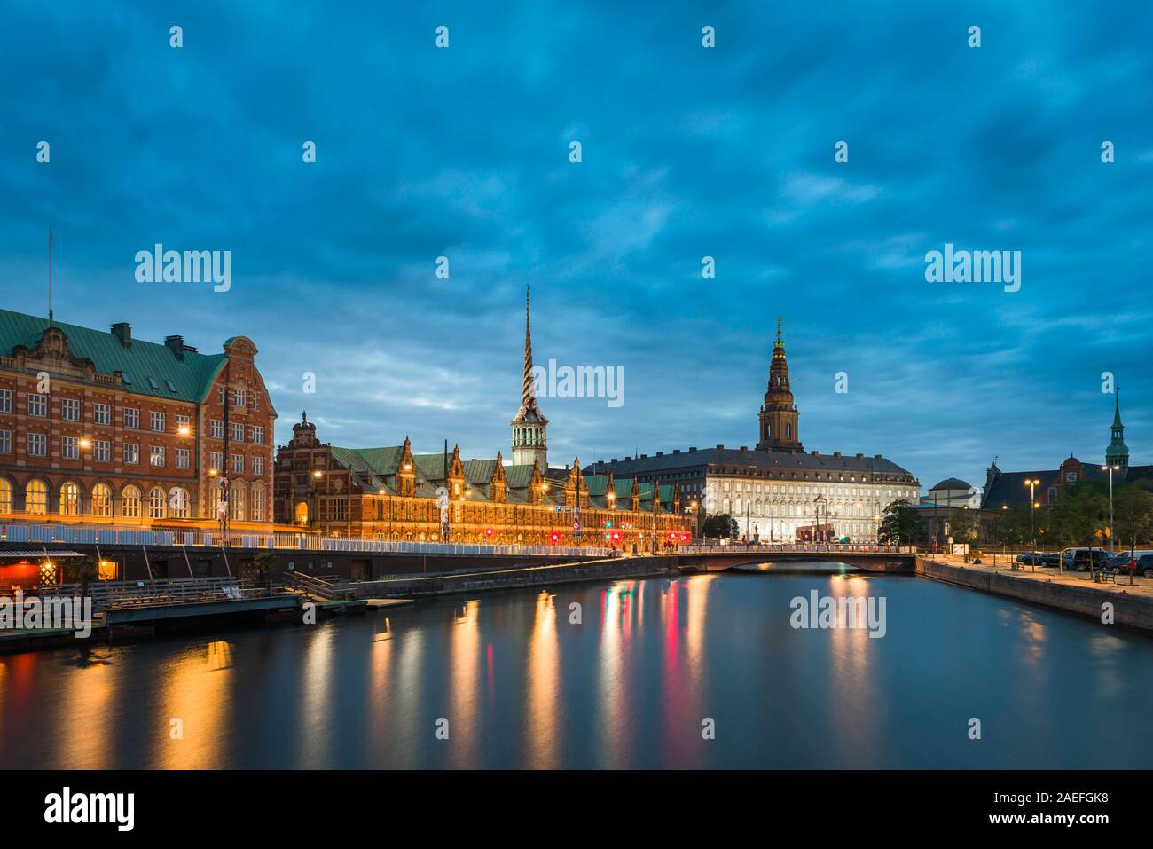 Noche de Copenhague, vista de Slotsholmen Borse canal con el edificio de la bolsa y Christianborg Slot (palacio), visible en la distancia, Copenhague. Foto de stock