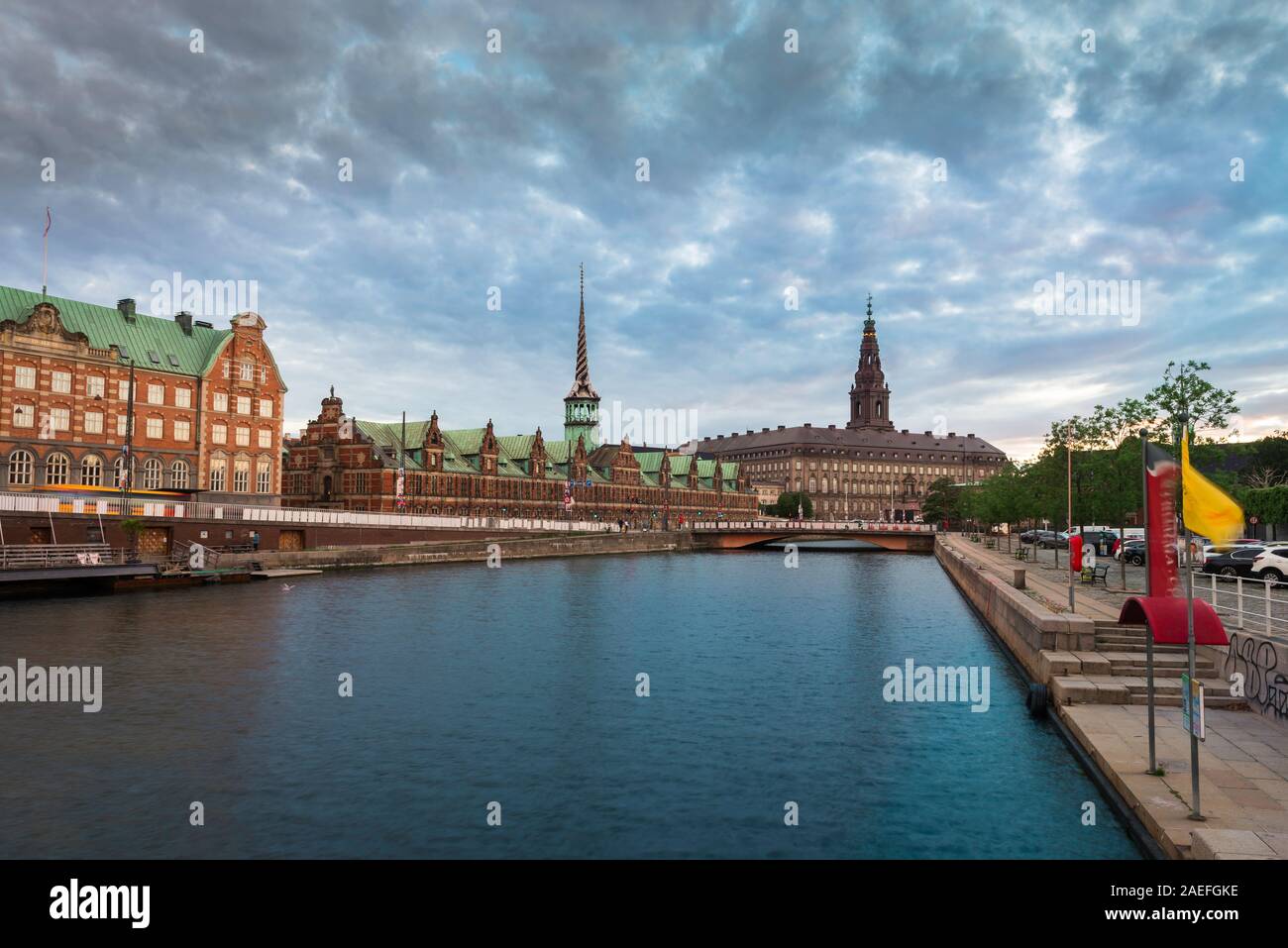 Ciudad de Copenhague, vista al atardecer del canal Slotsholmen con la bolsa de Borse y la ranura Christianborg (palacio) visible en la distancia, Copenhague Foto de stock