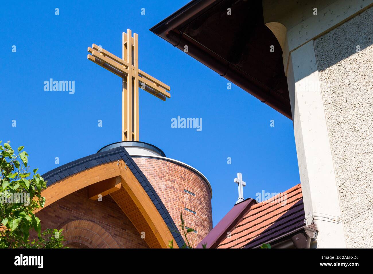 Viejo vs. el nuevo edificio de la iglesia Plebania Arpadhazi Szent Margit detalle con modernas grandes y viejos pequeñas cruces, Sopron, Hungría Foto de stock