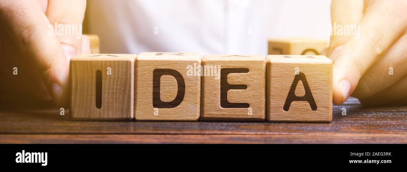 El empresario pone bloques de madera con la palabra idea. Generación de ideas empresariales innovadoras. Proceso creativo. La innovación y la solución. Inspiración Foto de stock