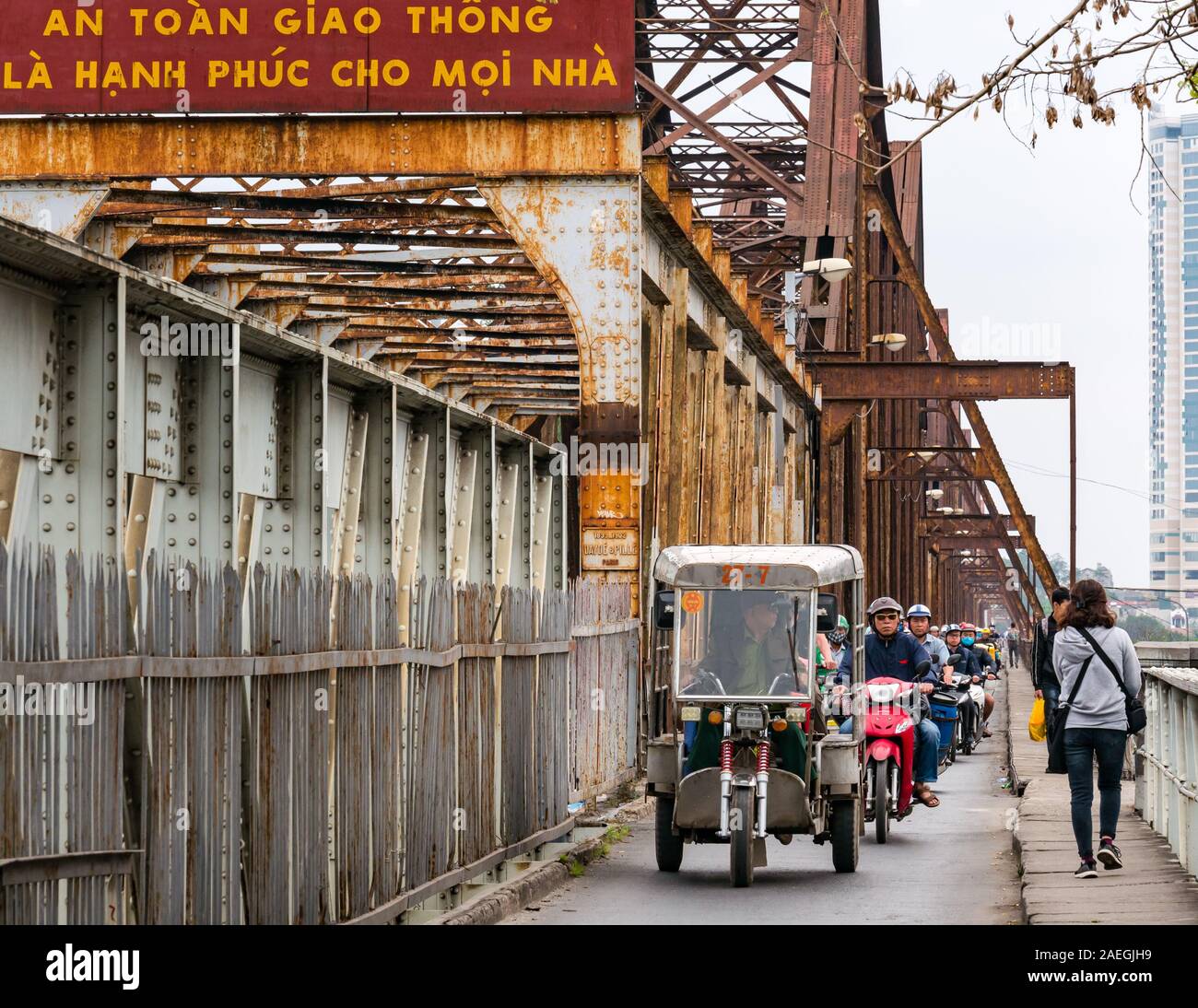 Tuk tuk y motocicletas en Long bien puente, Río Rojo, Hanoi, Vietnam, en el sudeste de Asia Foto de stock
