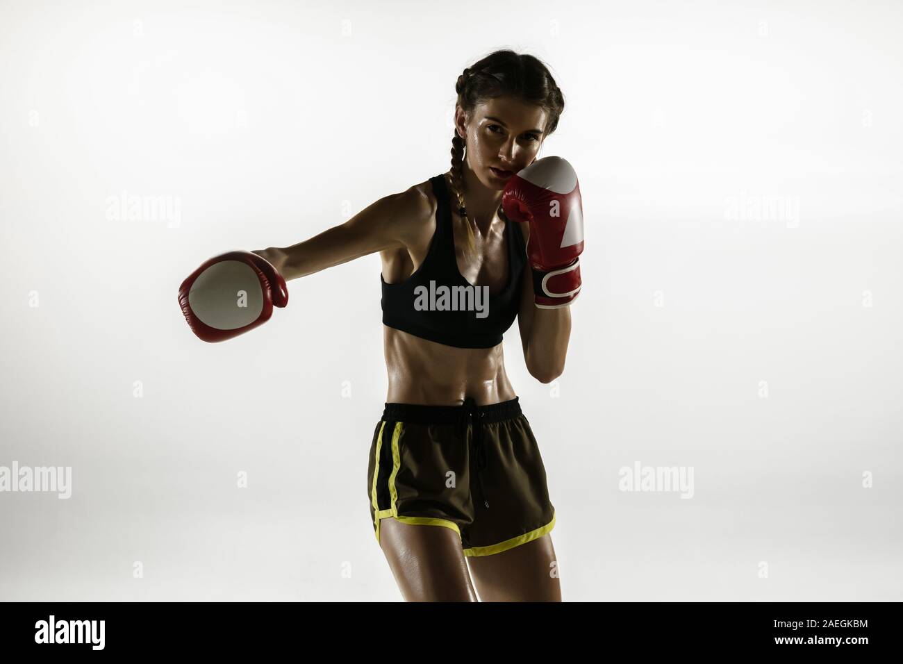 Imagen de hermosa grave mujer vistiendo ropa deportiva formación en guantes  de boxeo por mar de mañana Fotografía de stock - Alamy