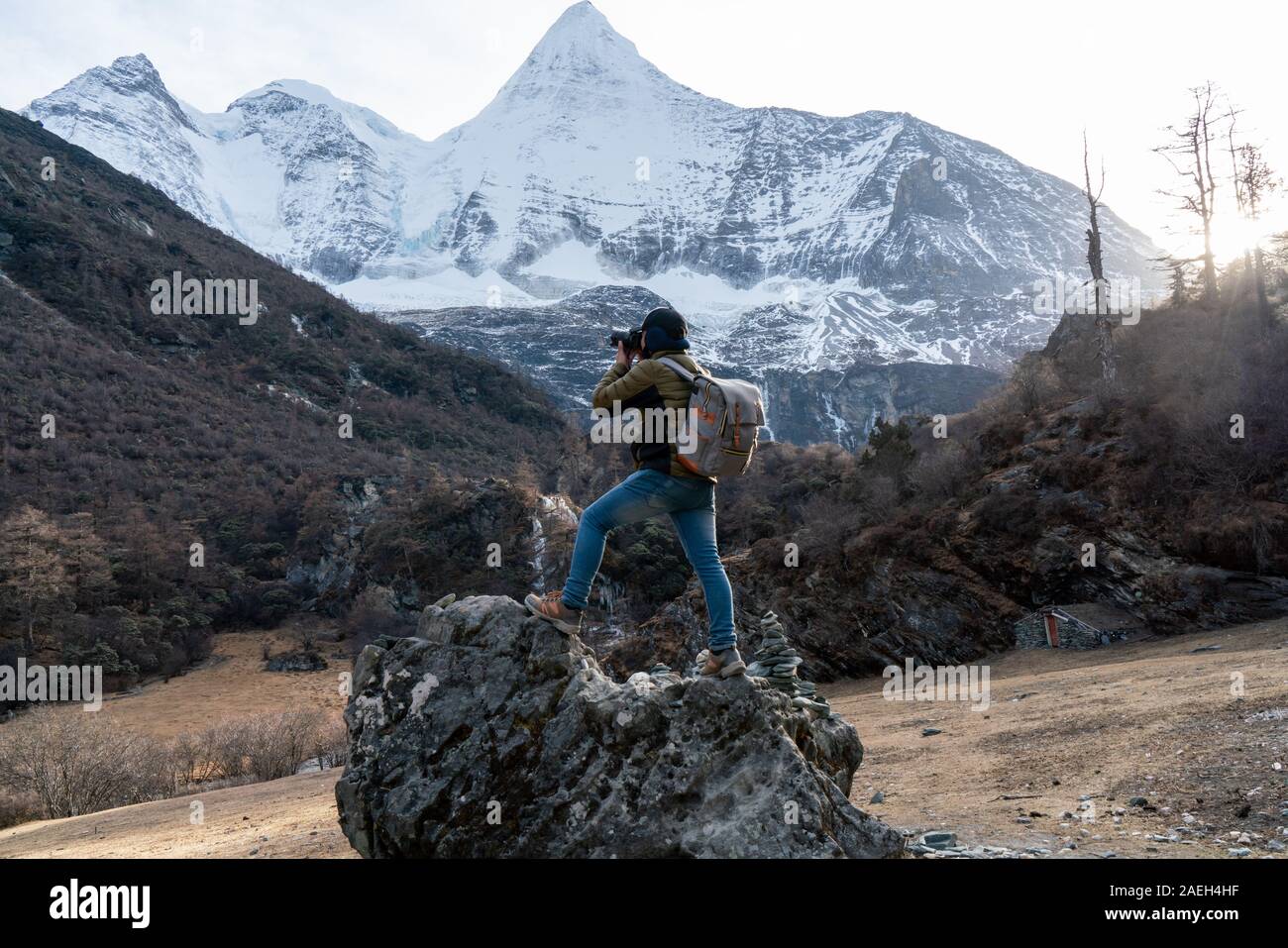 Joven fotógrafo, él está disfrutando de disparar nieve mirador de montaña de la Reserva Natural de Yading China Foto de stock