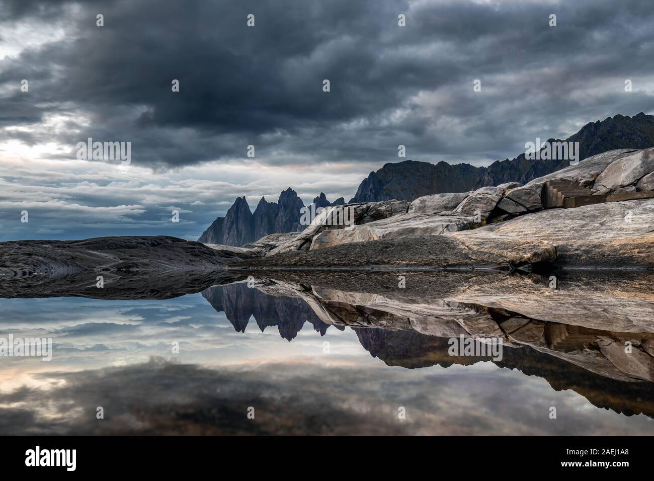 Costa en Tungeneset,ver más famosos picos de los dientes del diablo formación rocosa de la cordillera Okshornan, isla Senja, Troms, al norte de Noruega. Foto de stock