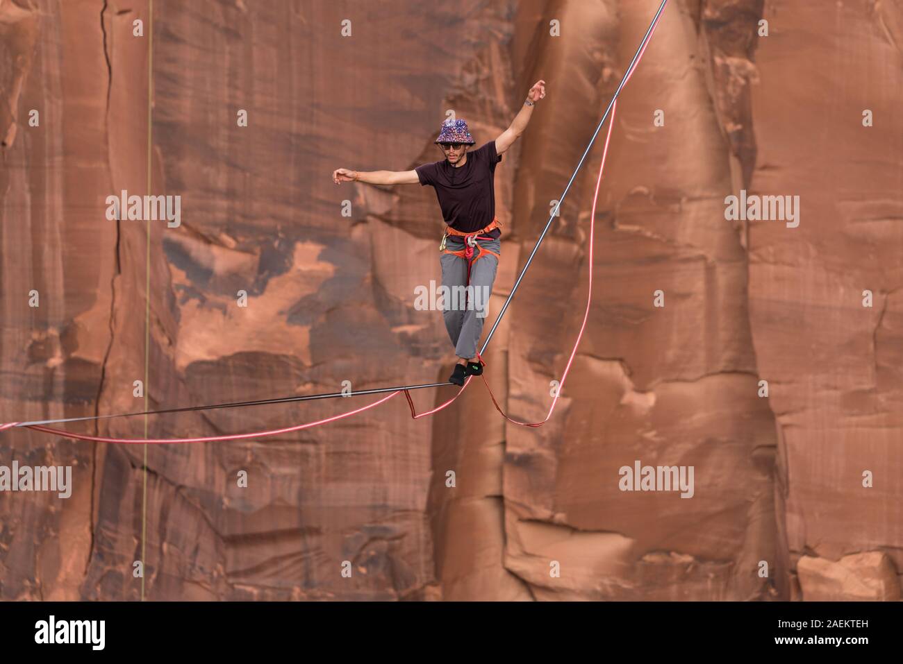 Un hombre joven highlining slacklining o a cientos de pies sobre minerales Canyon, cerca de Moab, Utah durante una highline encuentro. Foto de stock