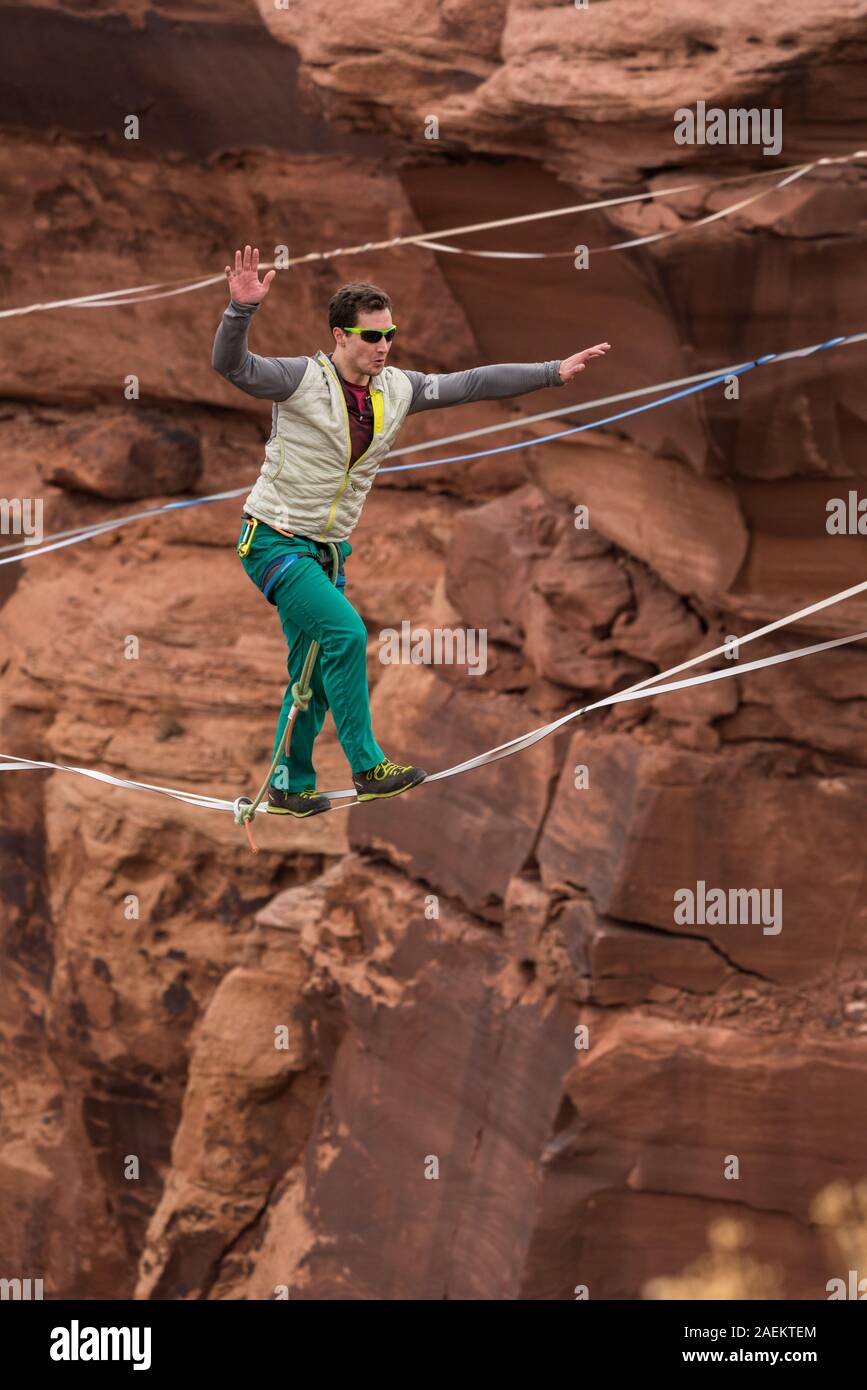 Un hombre joven highlining slacklining o a cientos de pies sobre minerales Canyon, cerca de Moab, Utah durante una highline encuentro. Foto de stock