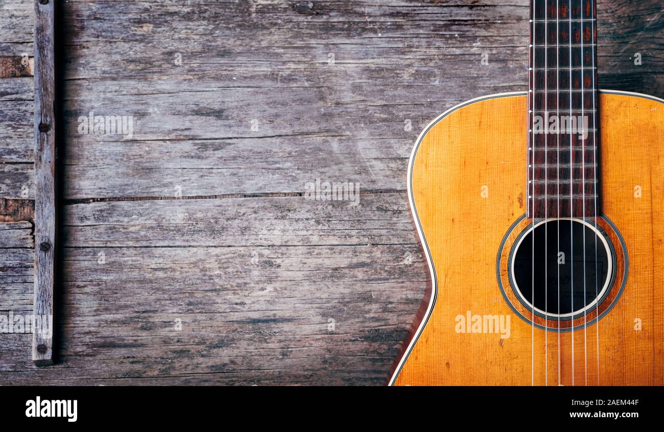 Primer plano de una vieja guitarra española acústica sobre fondo de madera  rústica desde arriba. La música popular melodía de la canción y el diseño  del banner. Vista desde arriba Fotografía de