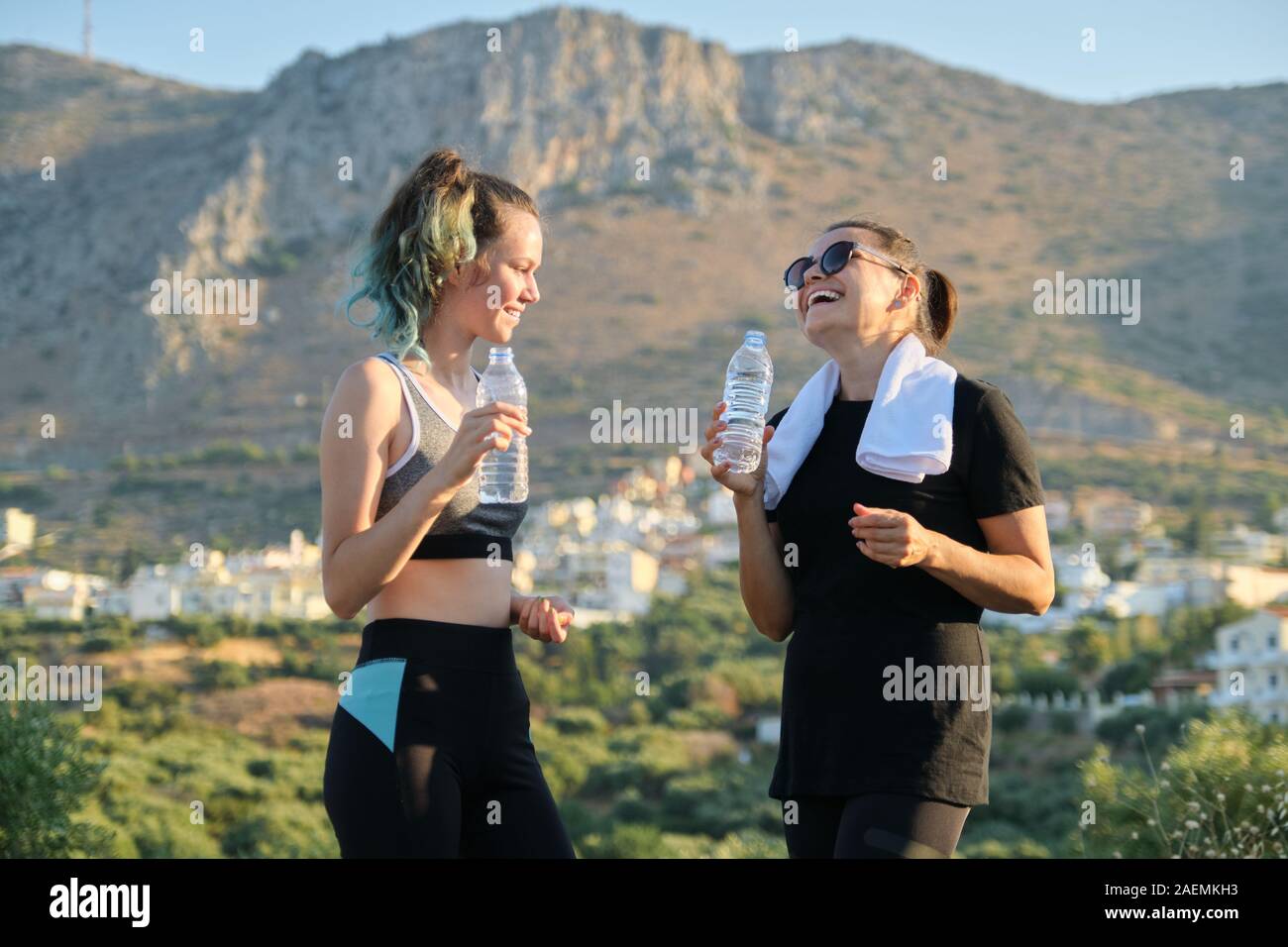 Madre e hija hablar y beber agua después de entrenar Foto de stock