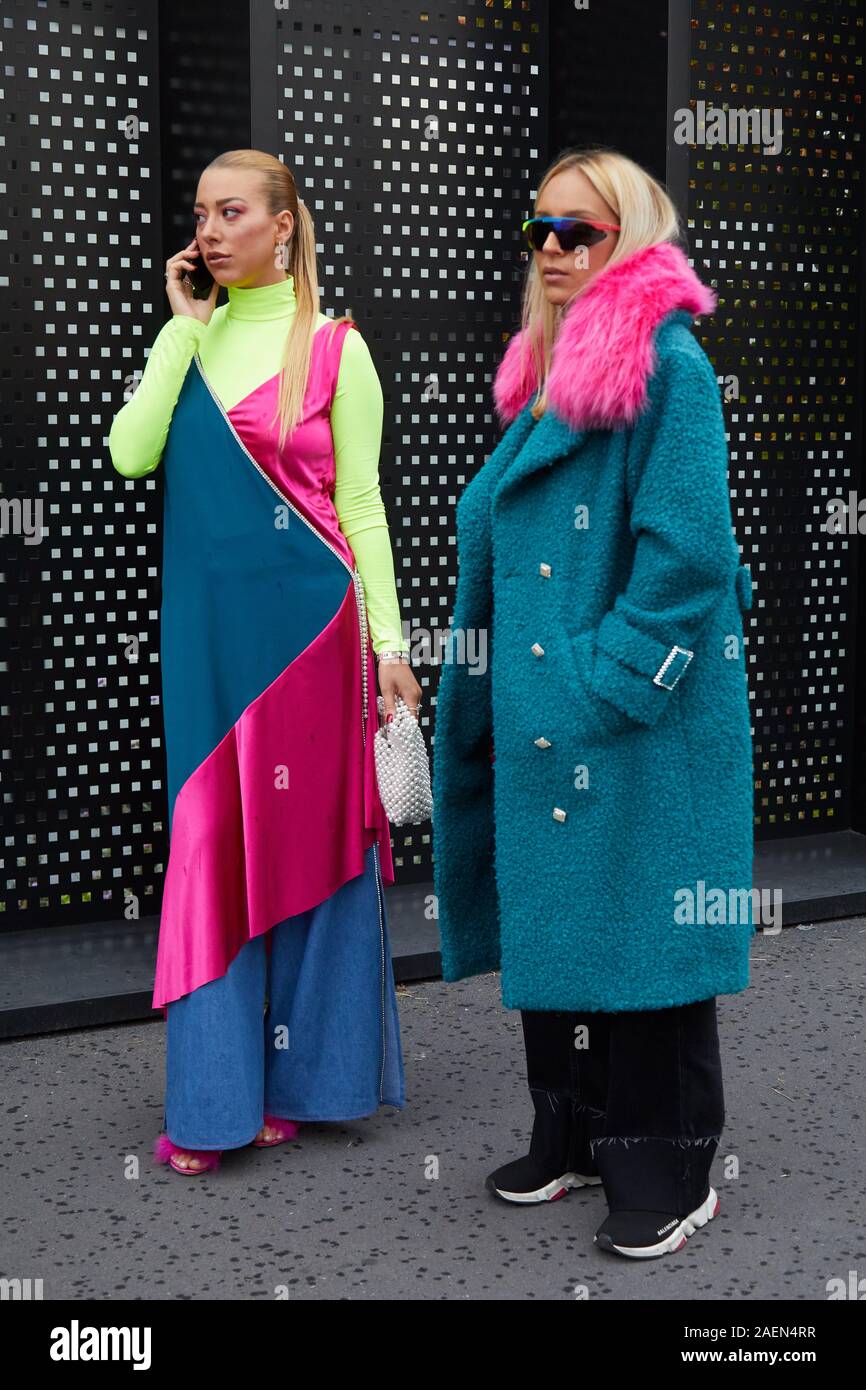 Milán, Italia - 22 de septiembre de 2019: la Mujer con abrigo azul con  cuello de piel rosa y amarillo vestido verde antes de Gucci Fashion Show,  la Semana de la moda