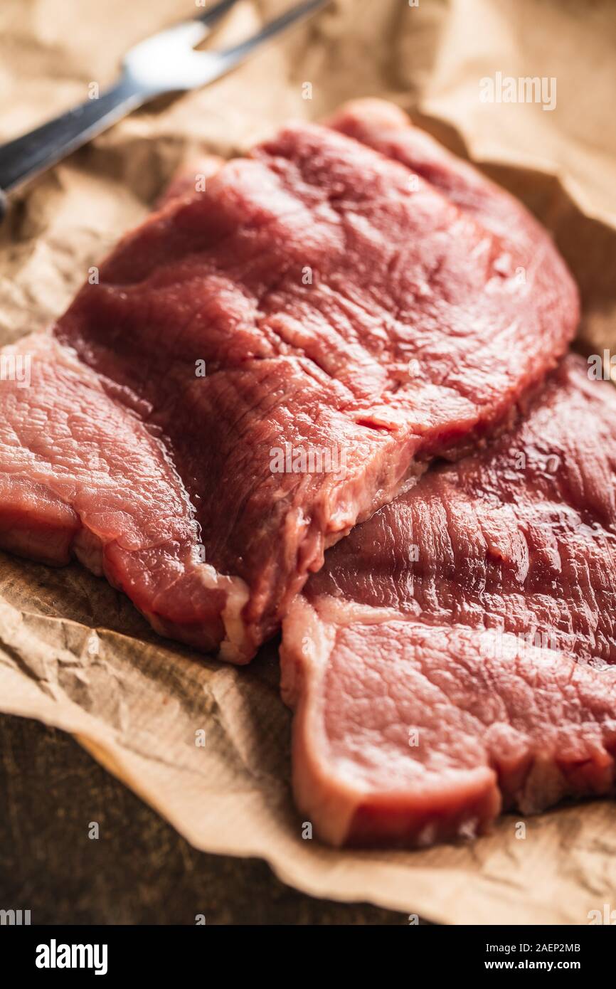 Materias Milanesa de ternera. Carne cruda sobre el papel. Foto de stock