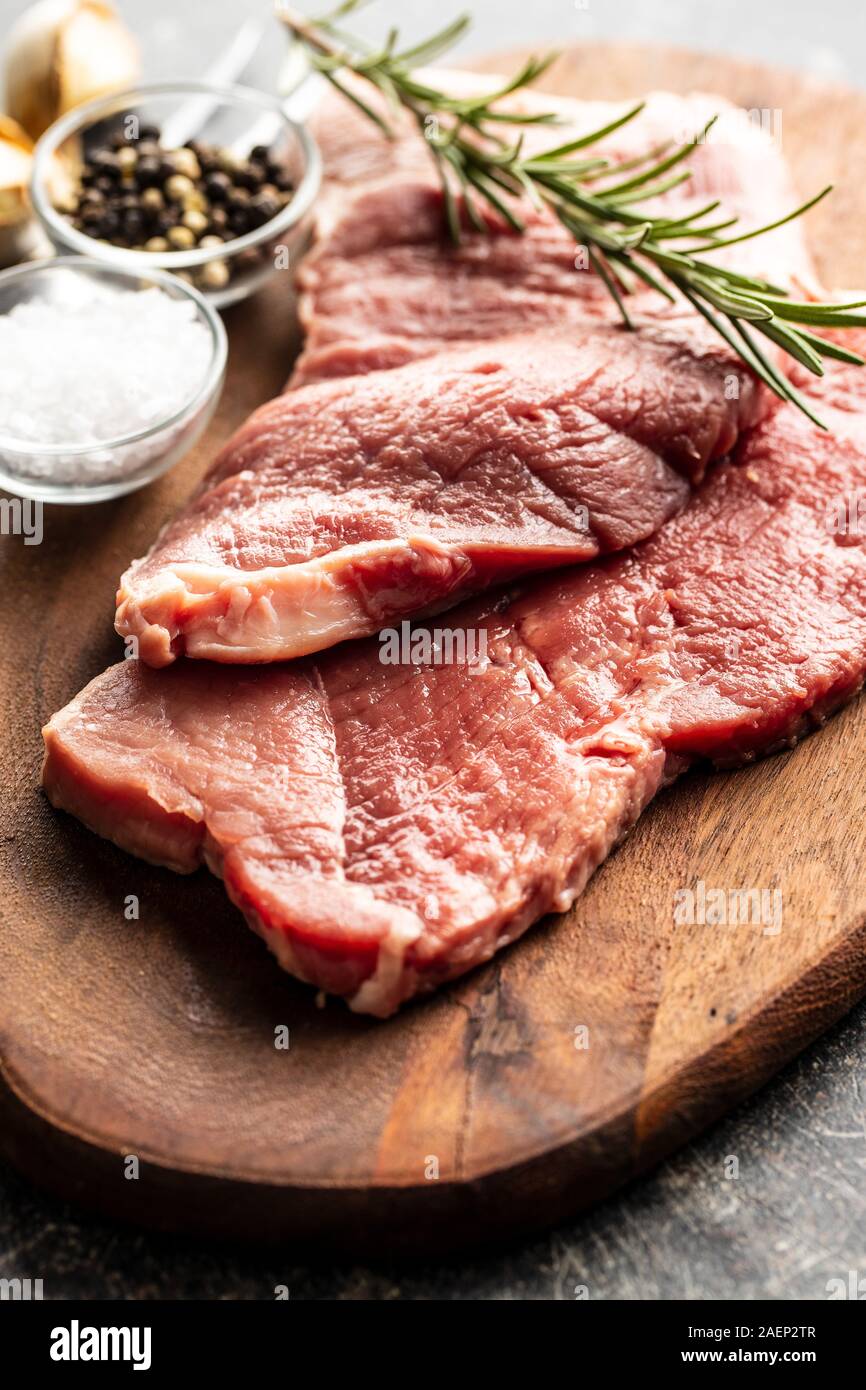 Materias Milanesa de ternera. Carne cruda sobre la placa de corte. Foto de stock