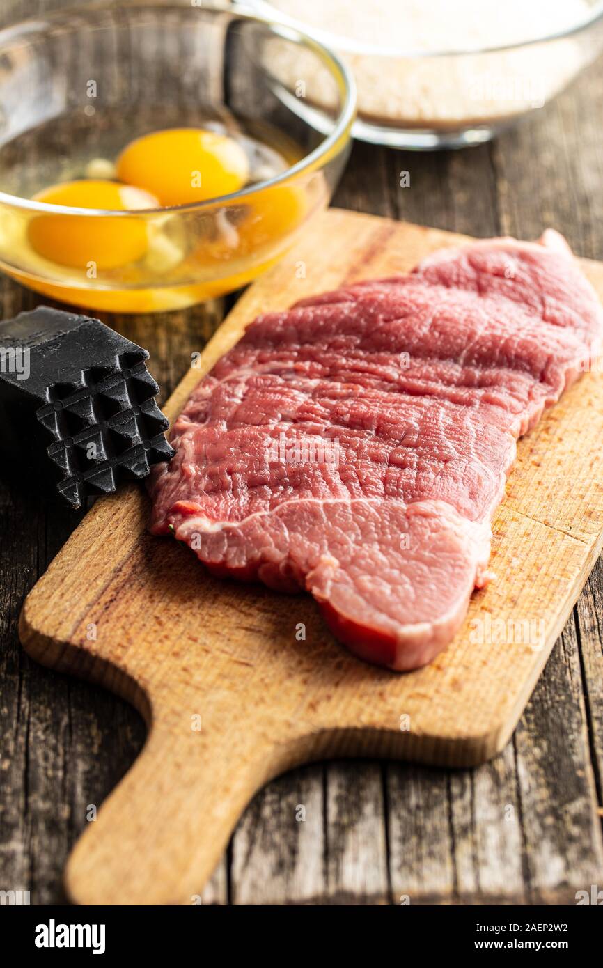 Materias Milanesa de ternera. Carne cruda sobre la placa de corte. Foto de stock