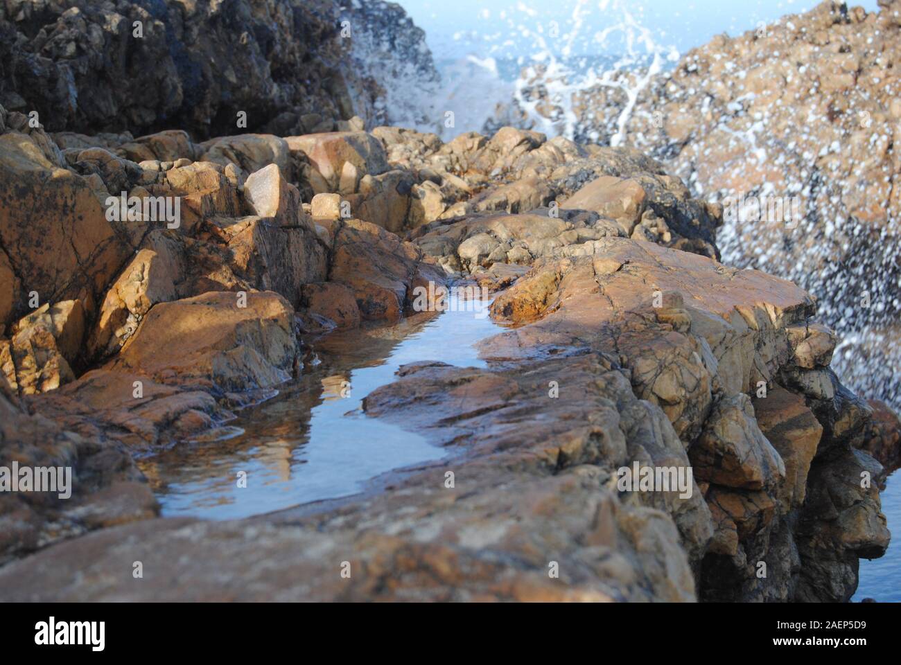 Pequeña playa de rocas con sky pool reflexión Foto de stock