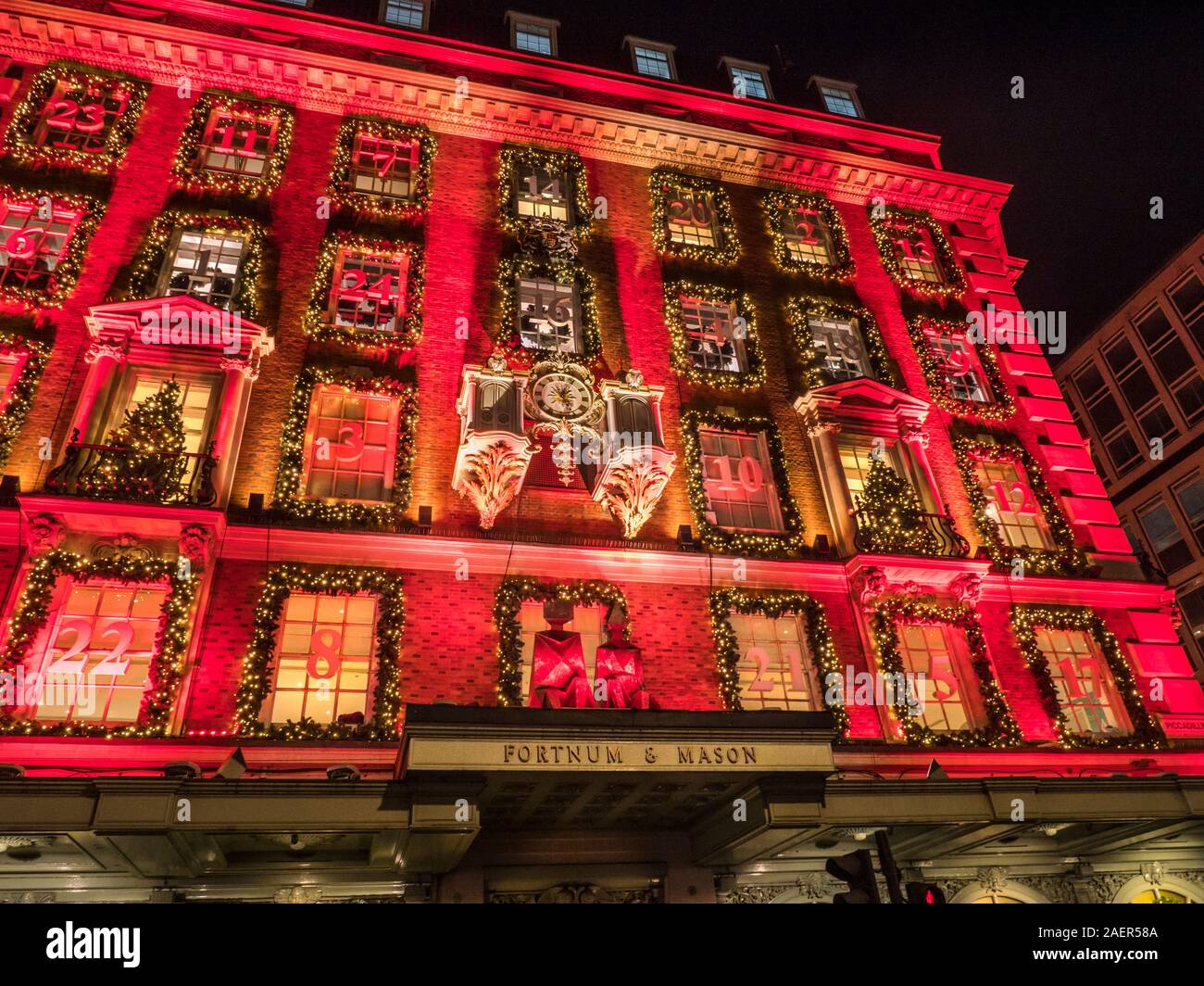 Navidad Fortnum & Mason department store fachada, con un calendario de Adviento tema rojo en la noche Piccadilly Londres Reino Unido 2019 Foto de stock